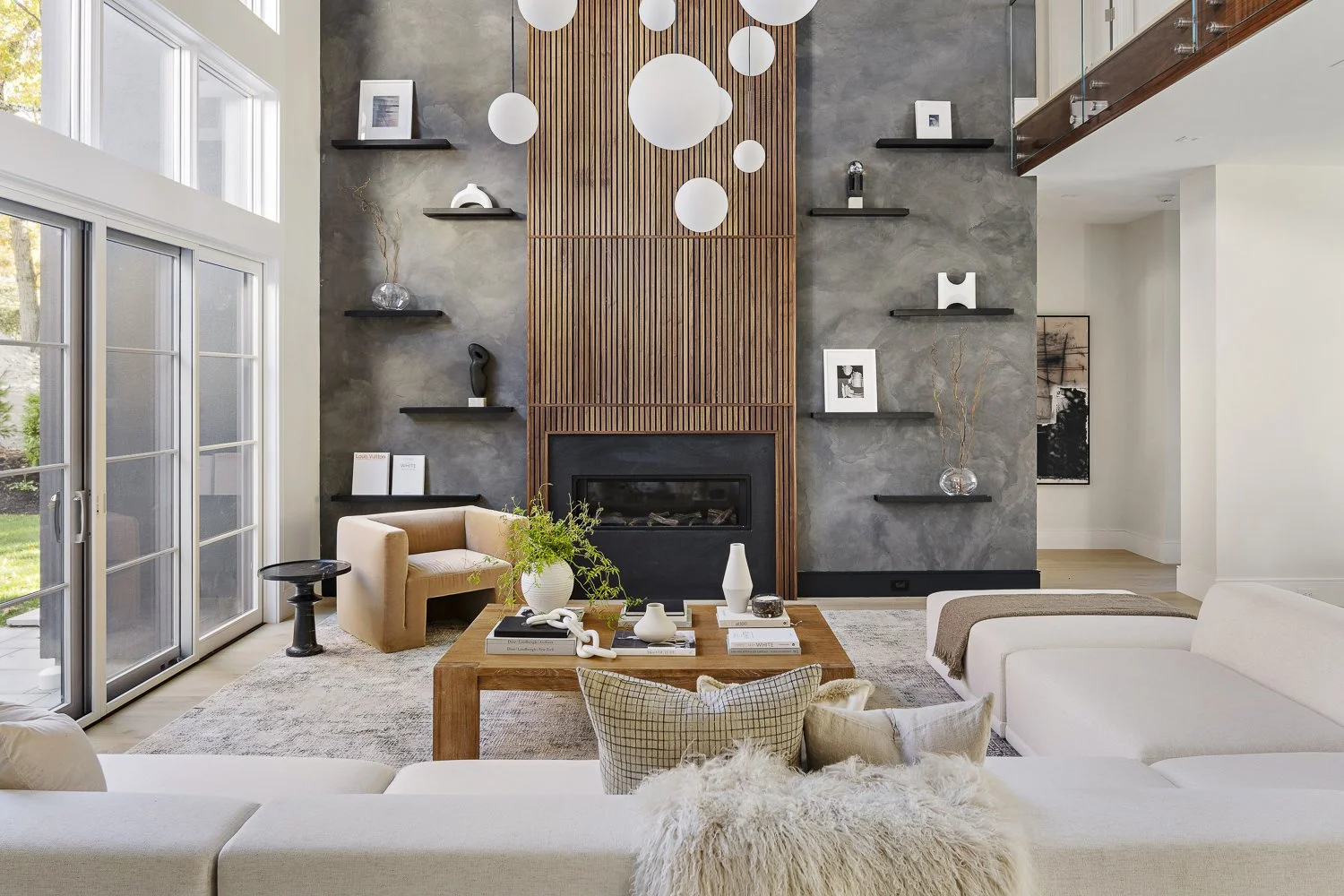 The living room with the textured accent wall + hanging globe lights