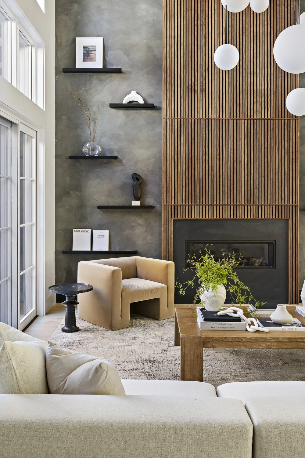 The living room with the textured accent wall + hanging globe lights