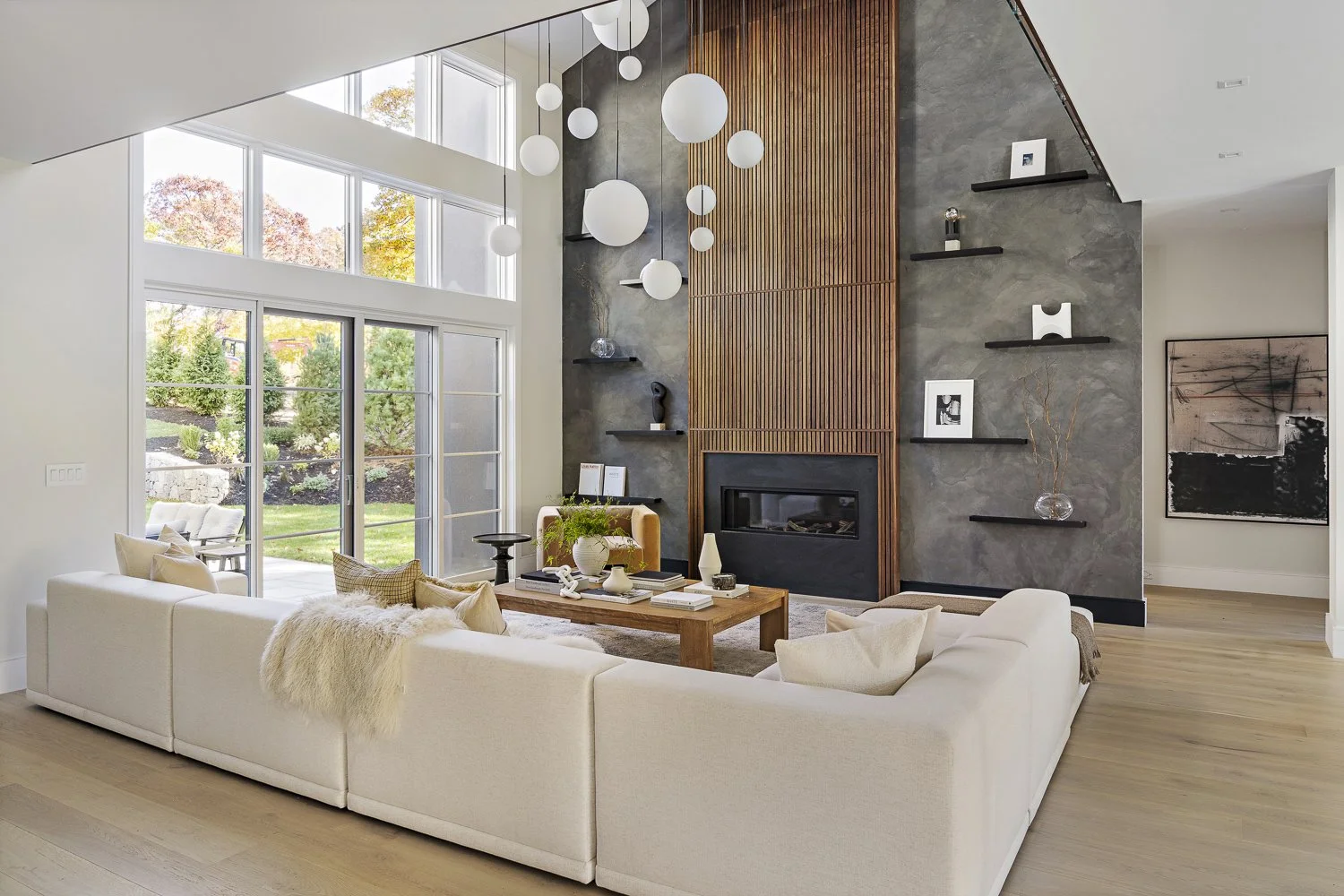 The living room with the textured accent wall + hanging globe lights