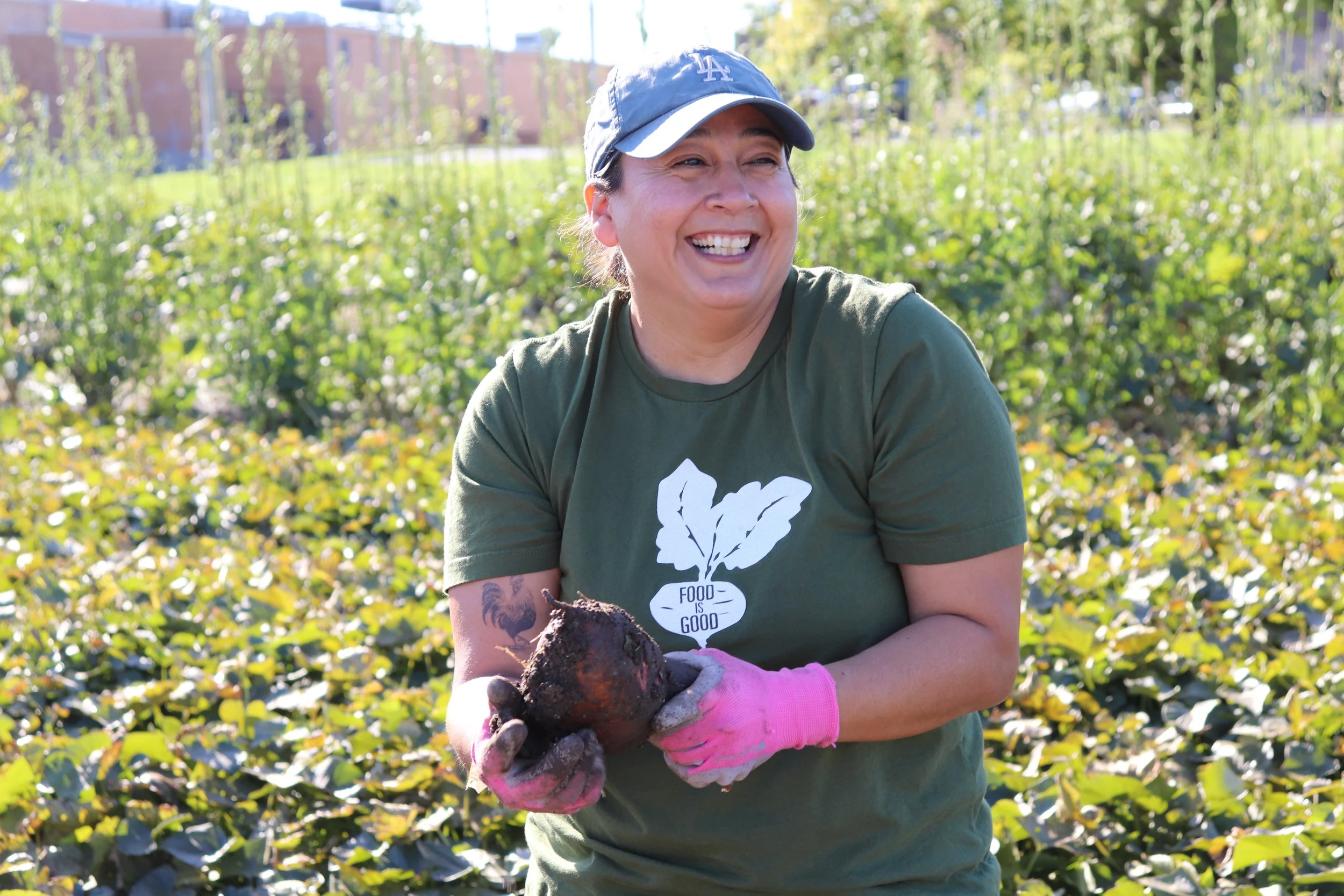 Market Garden Apprentice gaining hands-on skills in farming and agriculture smiling while harvesting sweet potatoes at Columbia's Agriculture Park