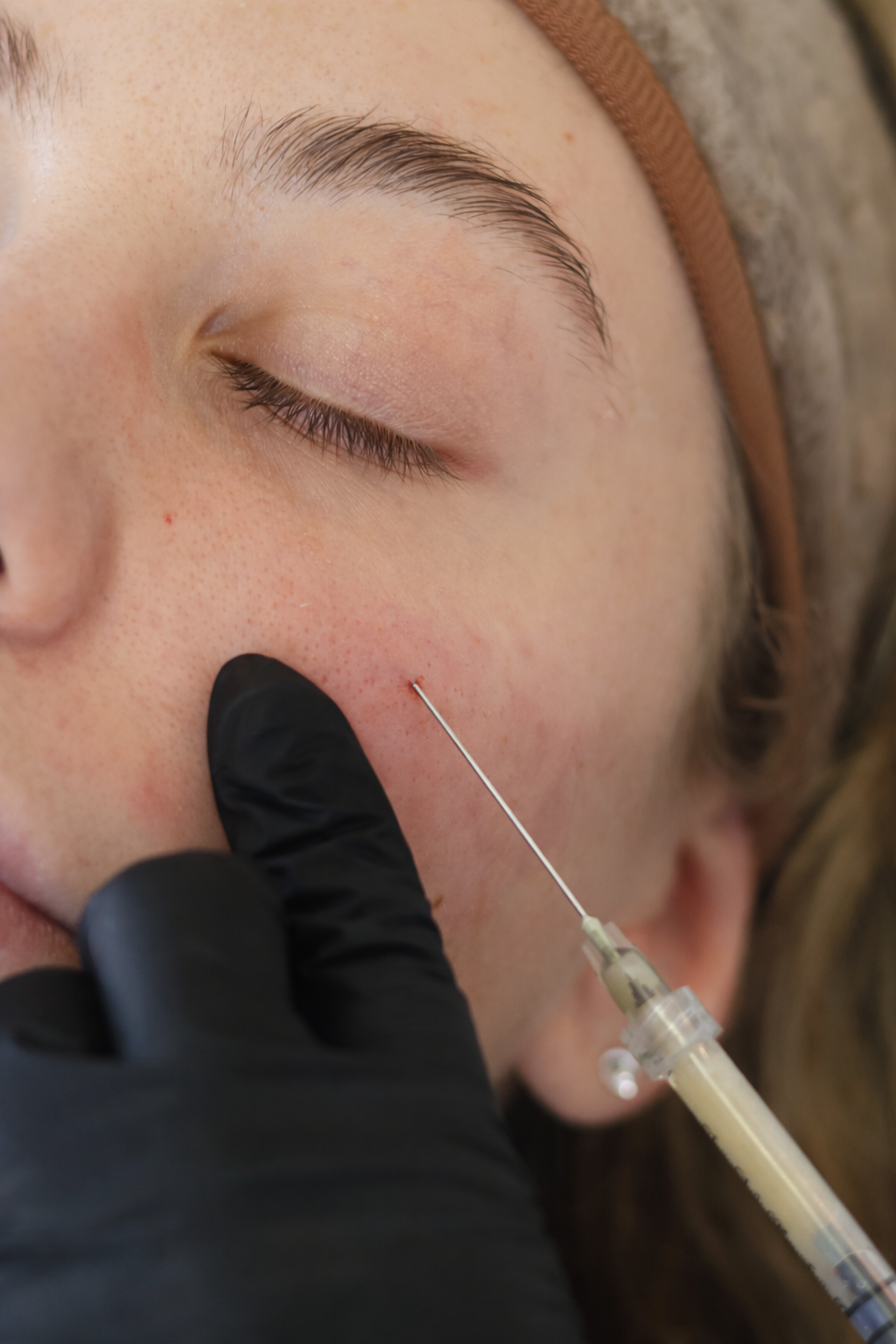 A close-up black and white photo of a woman's face focusing on her eyes and eyebrows.
