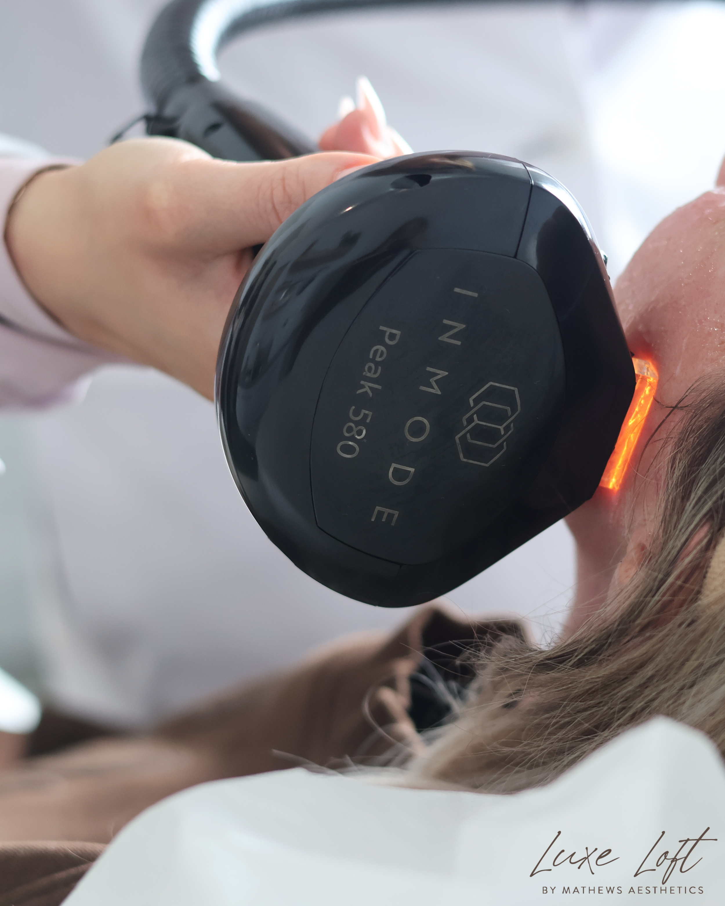 Person undergoing a dental examination with an intraoral camera or mirror in their mouth, in a clinical setting.
