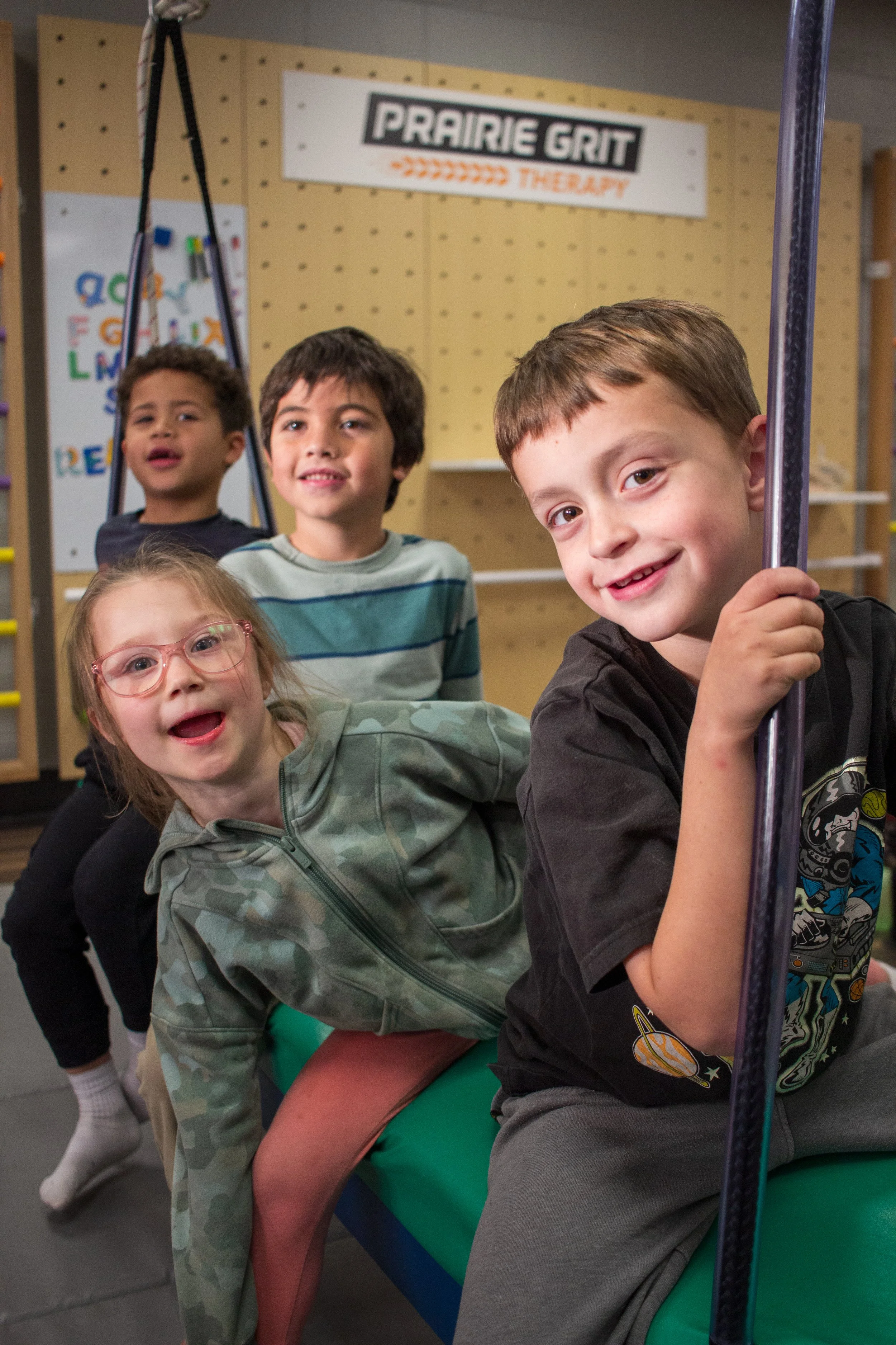 children standing in a line on a sensory swing