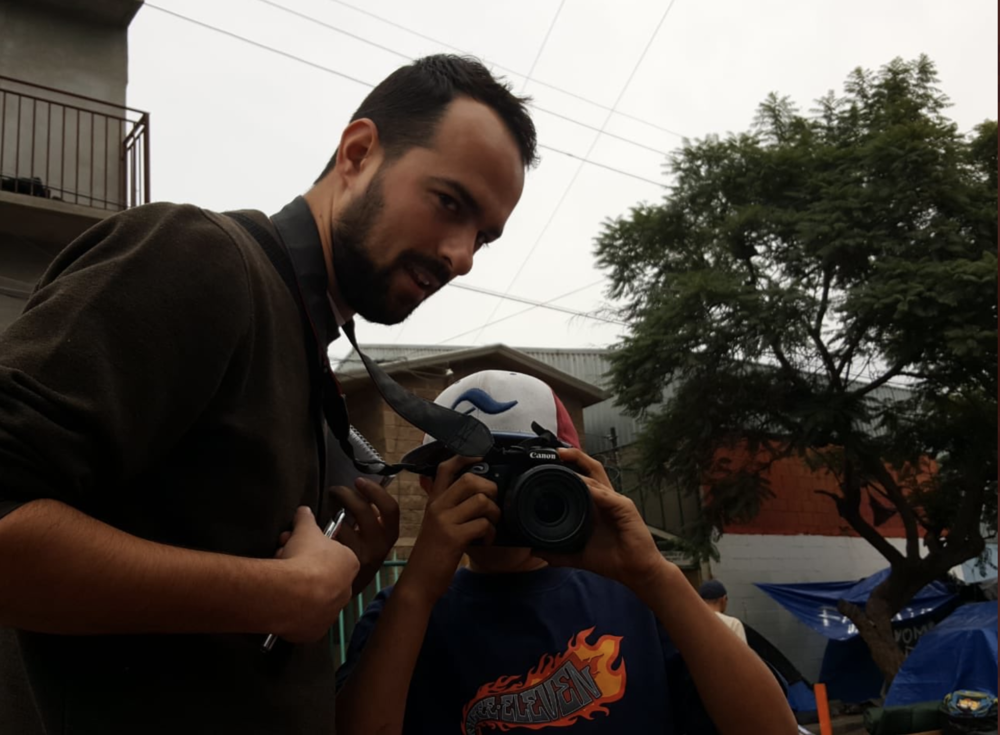 Jack Herrera pictured with a Guatemalan asylum seeker while reporting in Tijuana, Mexico in 2019. (Courtesy of Jack Herrera)