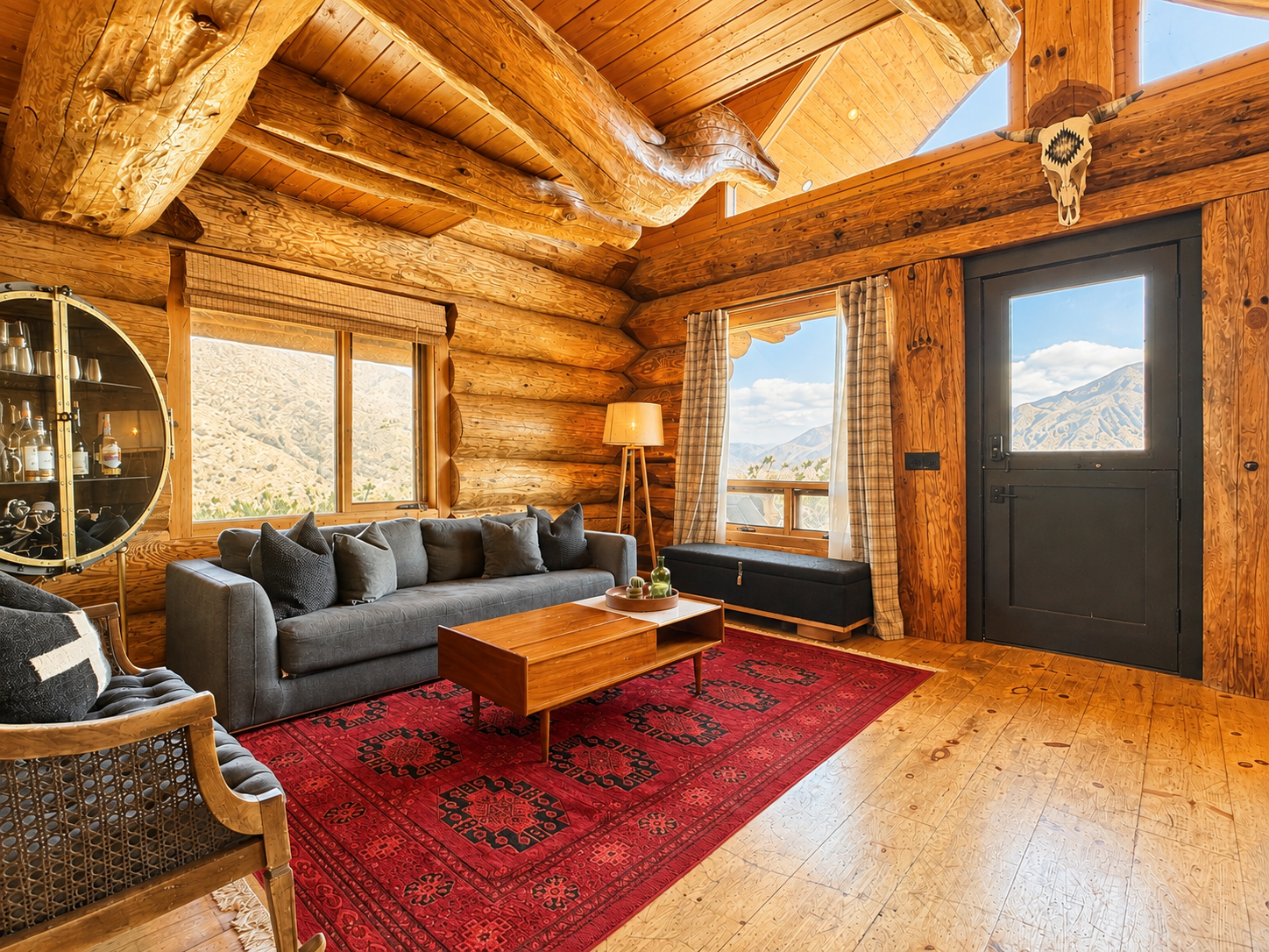 Log cabin living room with mountain views through windows on three sides