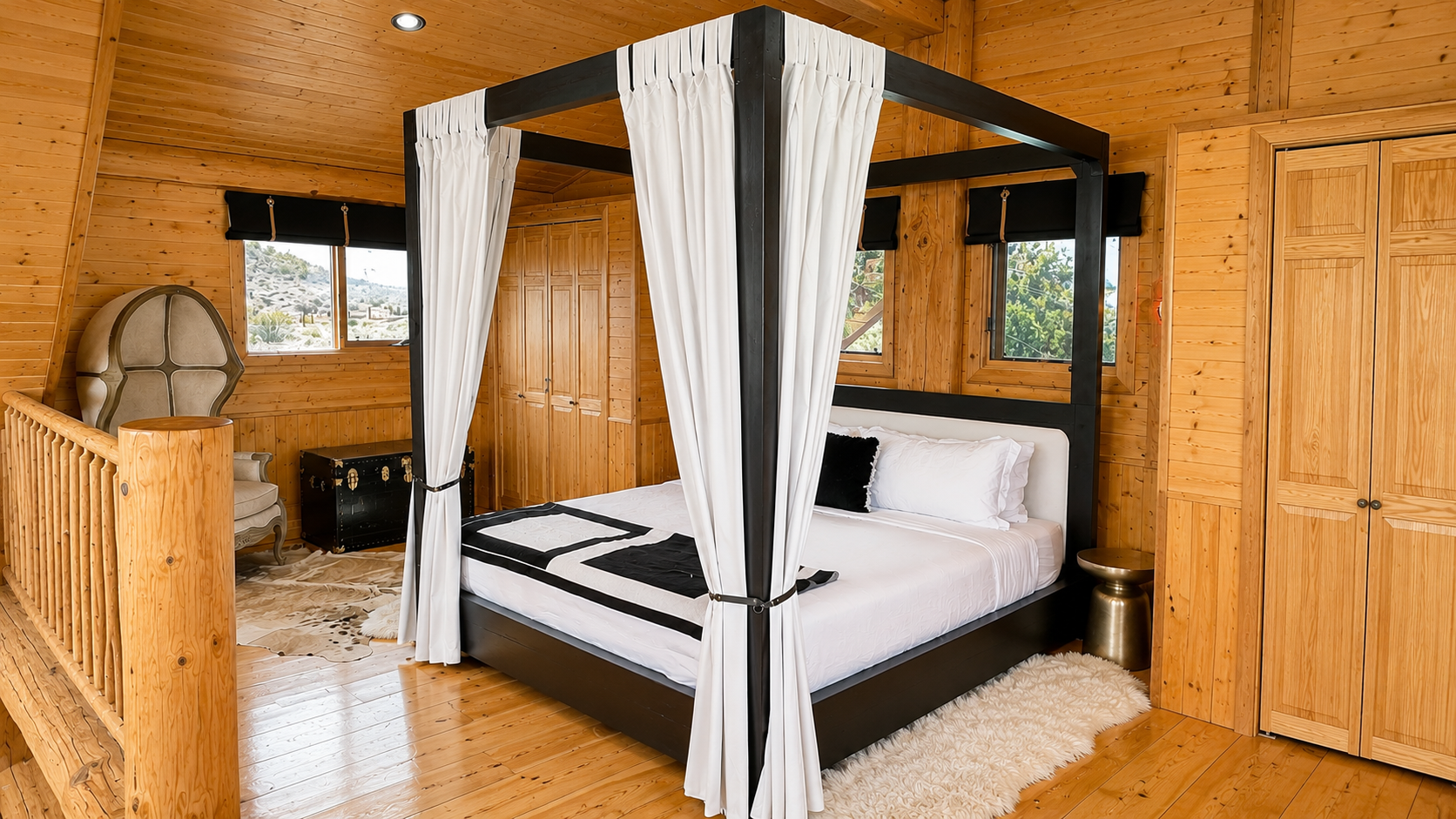 King canopy bed with linen drapes in the open cabin loft