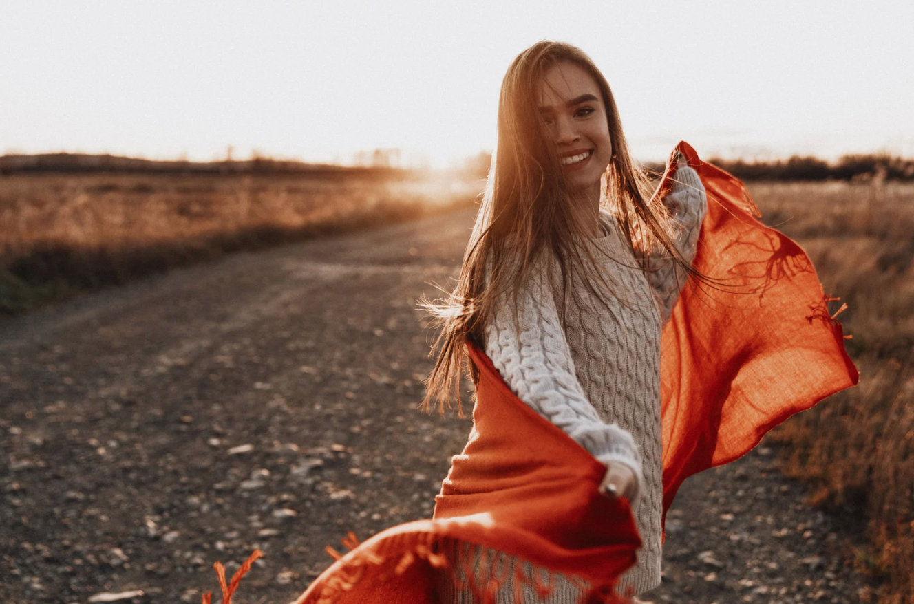 Happy woman smiling in a field because she has completed a successful OCD therapy local to San Diego, California