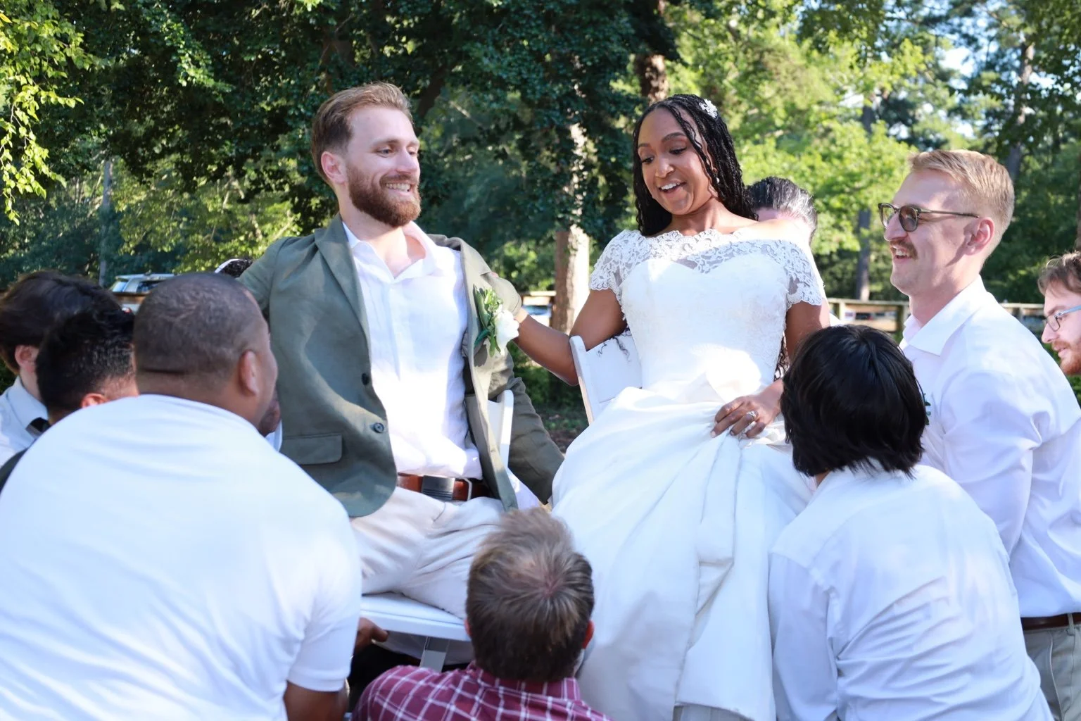 The newlyweds celebrate with family and friends at an outdoor wedding.