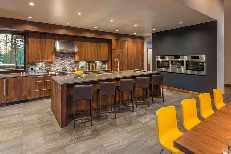 Photo of a modern kitchen interior in brown and gray with bright yellow chairs