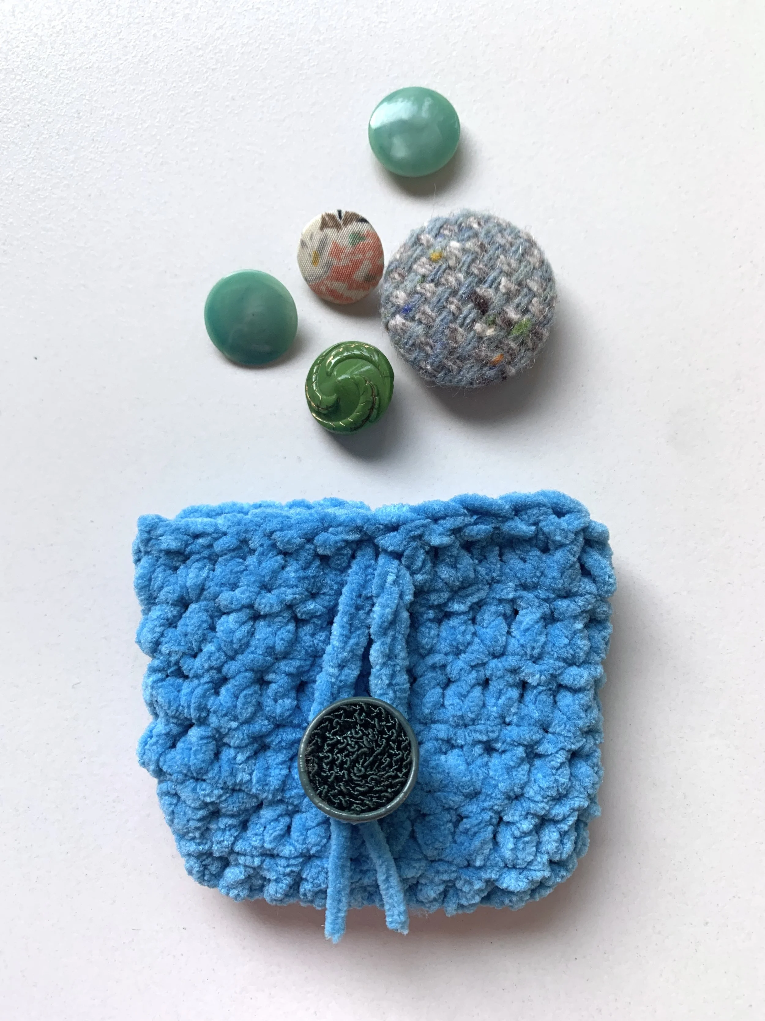 Gehaakt airpodcase. In zachte 
chenille garen.
Deze sluit met een knoop
uit de kringloopwinkel♻️