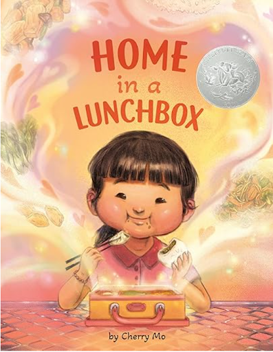 Home in a Lunchbox by Cherry Mo tells the story of Jun, a young girl who moves from Hong Kong to America and struggles with language and feeling out of place at her new school. When she opens her lunchbox and sees familiar foods like bao, dumplings, 