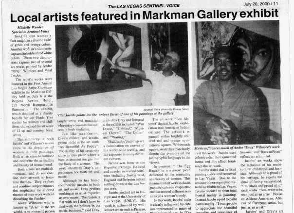 Photograph of an art gallery reception, featuring two artists presenting their paintings. The artwork includes vibrant, expressive portraits. A woman gestures towards a piece as guests observe the displayed art.