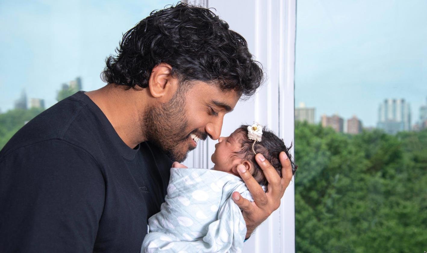 Father nose to nose with his newborn by the window during a Fresh48 hospital photo session at NYC Health + Hospitals/Elmhurst, Queens