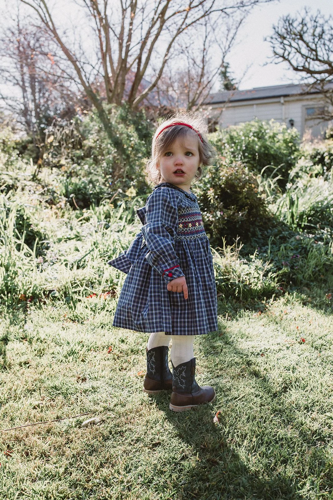 Cute baby wears smocked dress in the Southern Highlands in Australia.