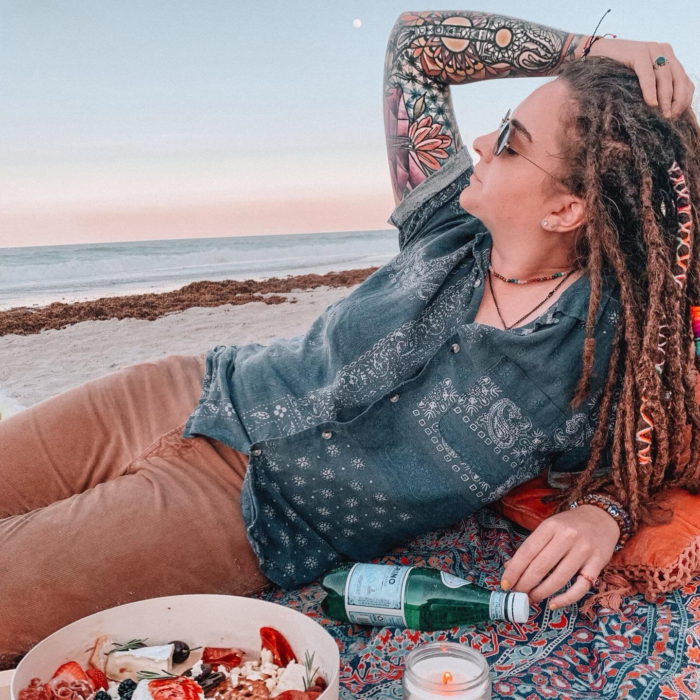 Hanging out on the beach at sunset is probably my favorite part of summer 🌅🍒 #indieartist #beachvibes #beach #beachpicnic #charcuterieboard #cherries #independentartist #orlandoflorida #daytonabeach #chillin #perrier #sunset #dreadlocks #girlswhoki