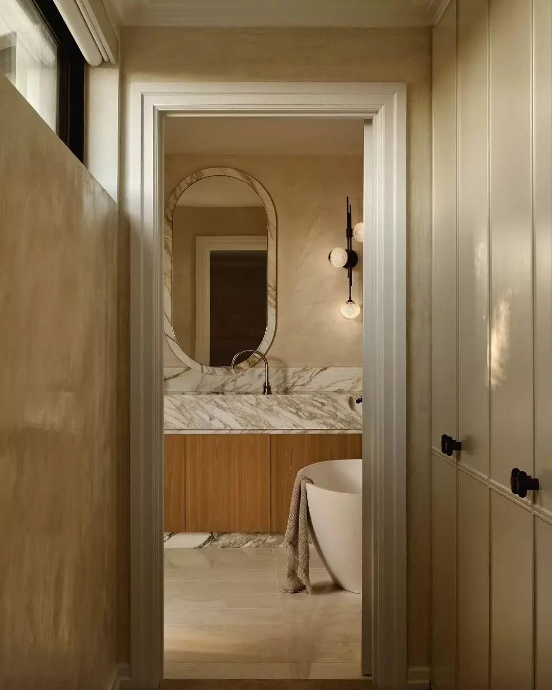 GUEST APPEAL &bull; Step into the serene elegance of Residence B's guest ensuite, where timeless design meets modern luxury. Featuring bespoke Calacatta Vagli marble accents on the vanity, kick, and mirror frame, paired with warm oak timber veneer an