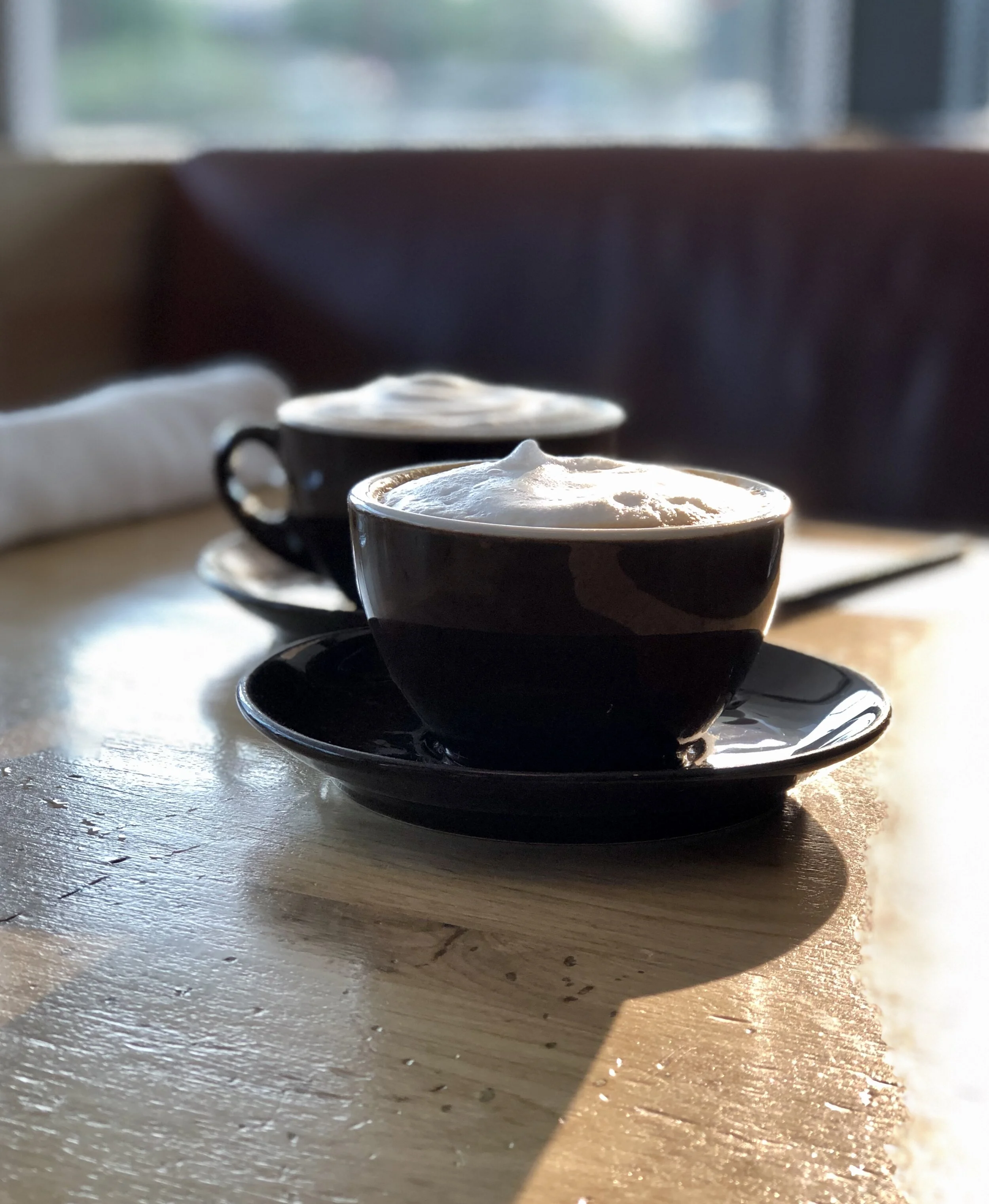 Two freshly made cappuccinos at Ace Motel & Swim Club in Palm Springs, California, USA, catching the first rays of sun. Perfect antidote for two jet lagged travelers.
