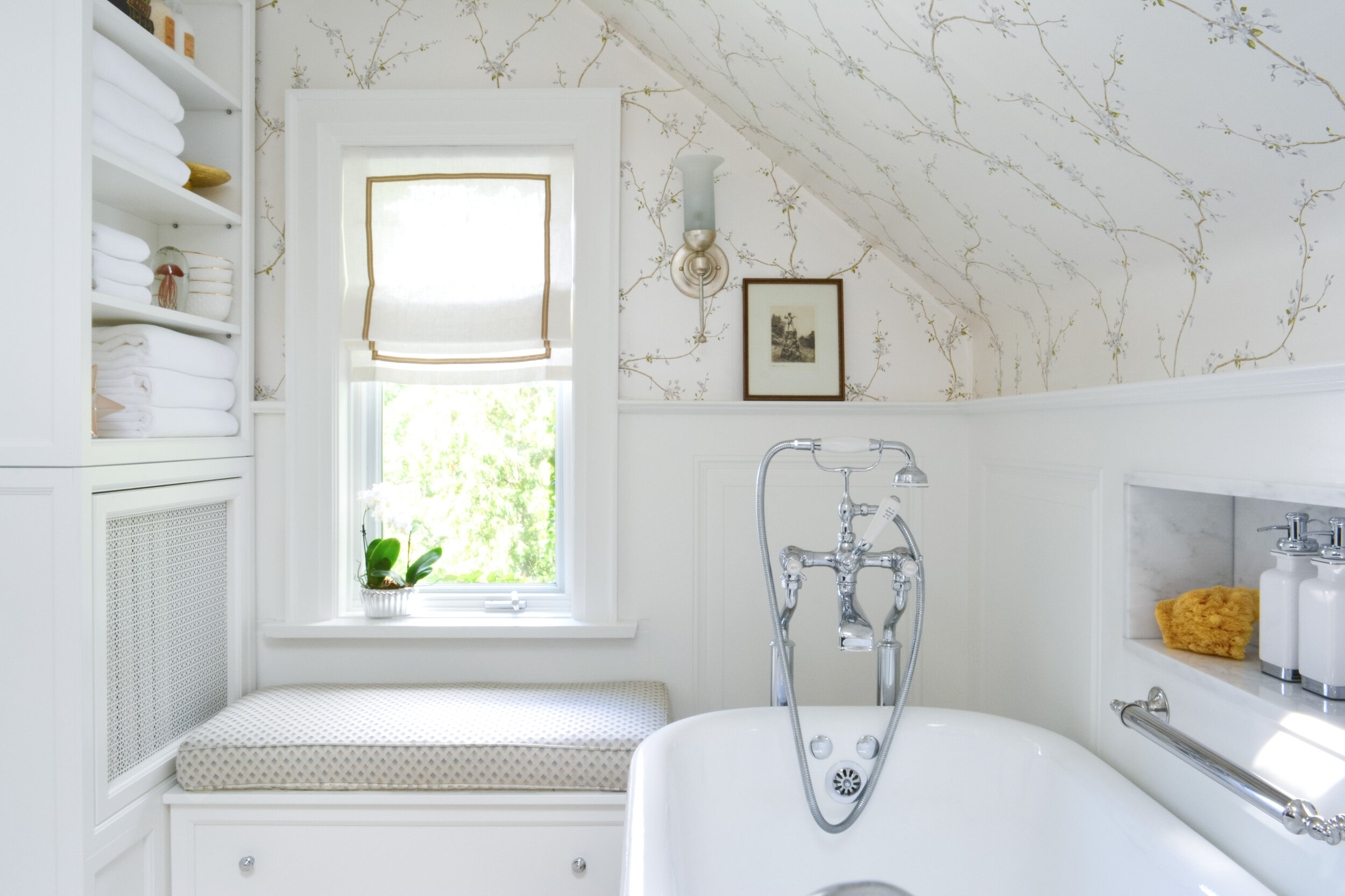 Century home bathroom renovation by Mimi Pineau Design in Swansea Toronto features a clawfoot bathtub, nickel faucet, custom window seat, custom cabinetry and radiator cover, wainscoting, wallpaper and fabric roman blind.
