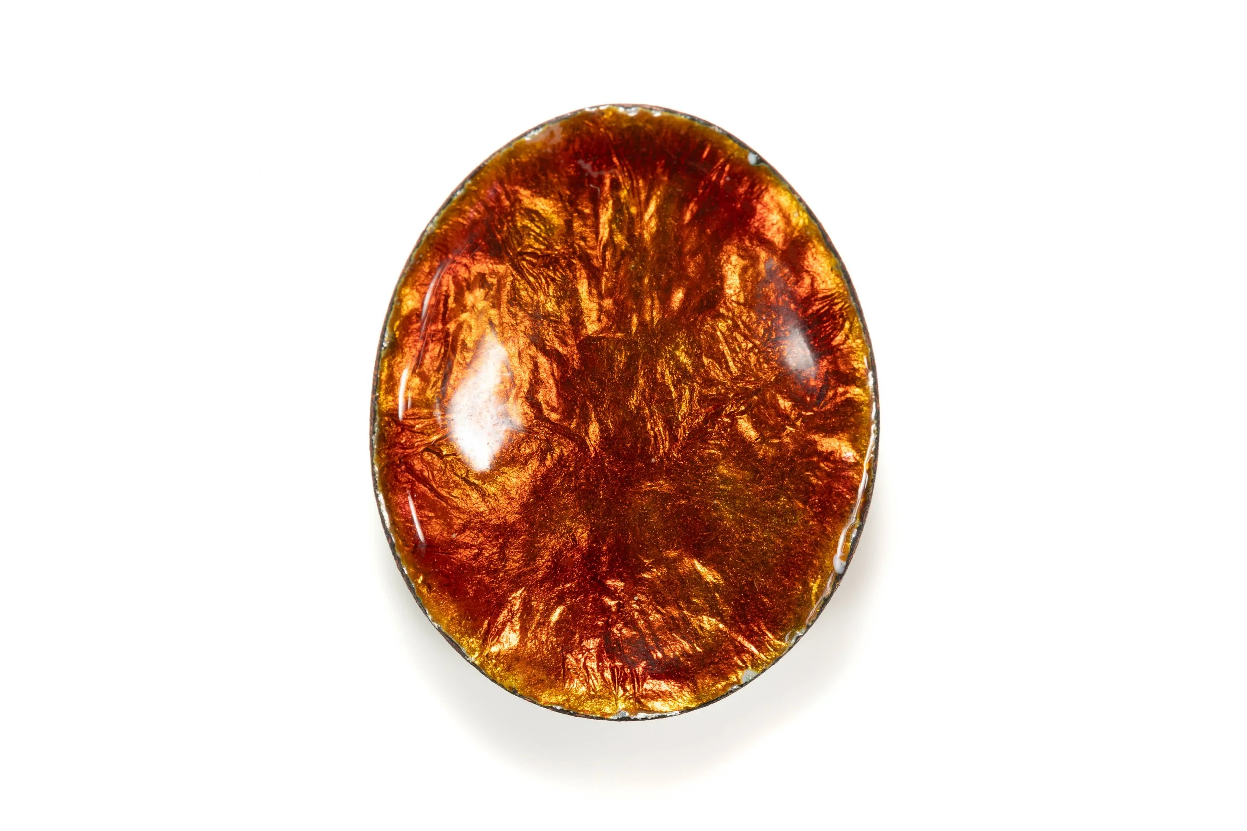 Rear view of the pansy enamel cabochon, showing its glossy amber-brown oval back.