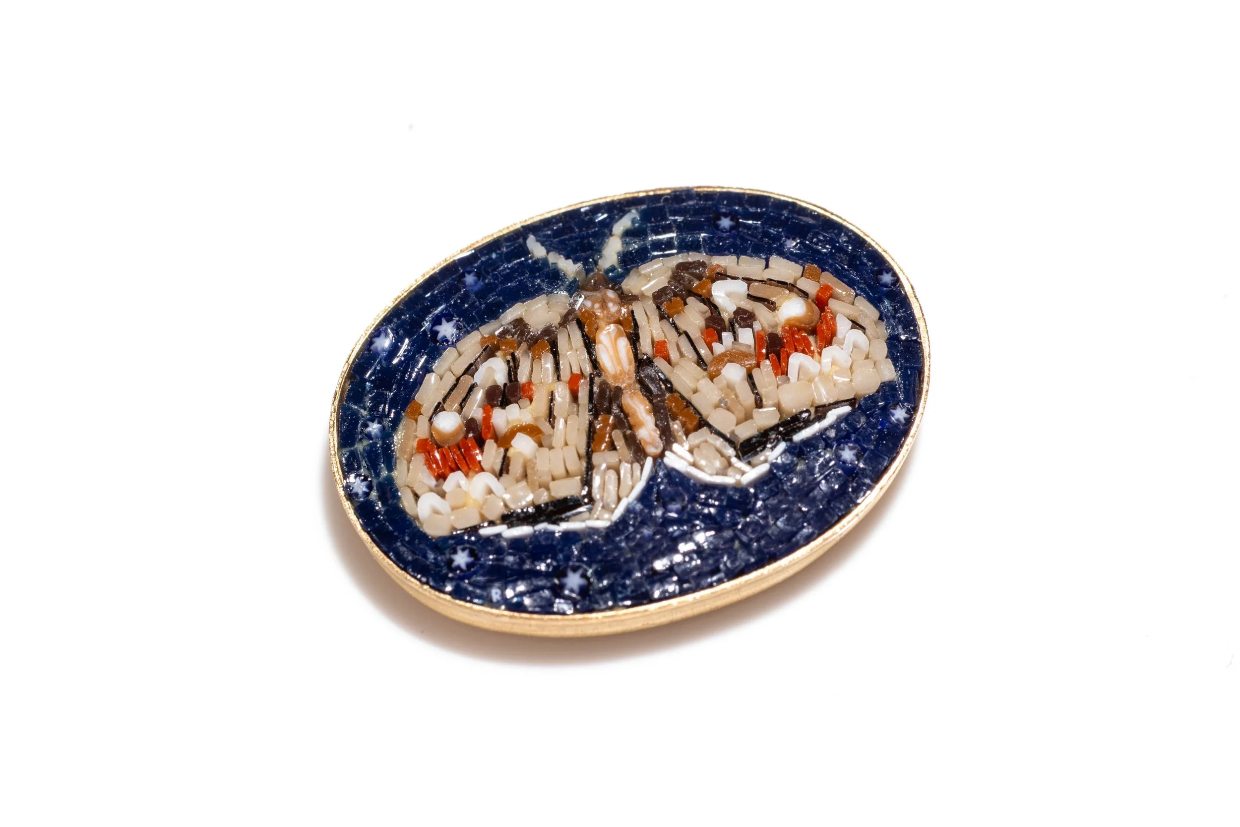 Close angled view of the moth micromosaic, showing the patterned wings, glass tesserae and gold-colored rim.