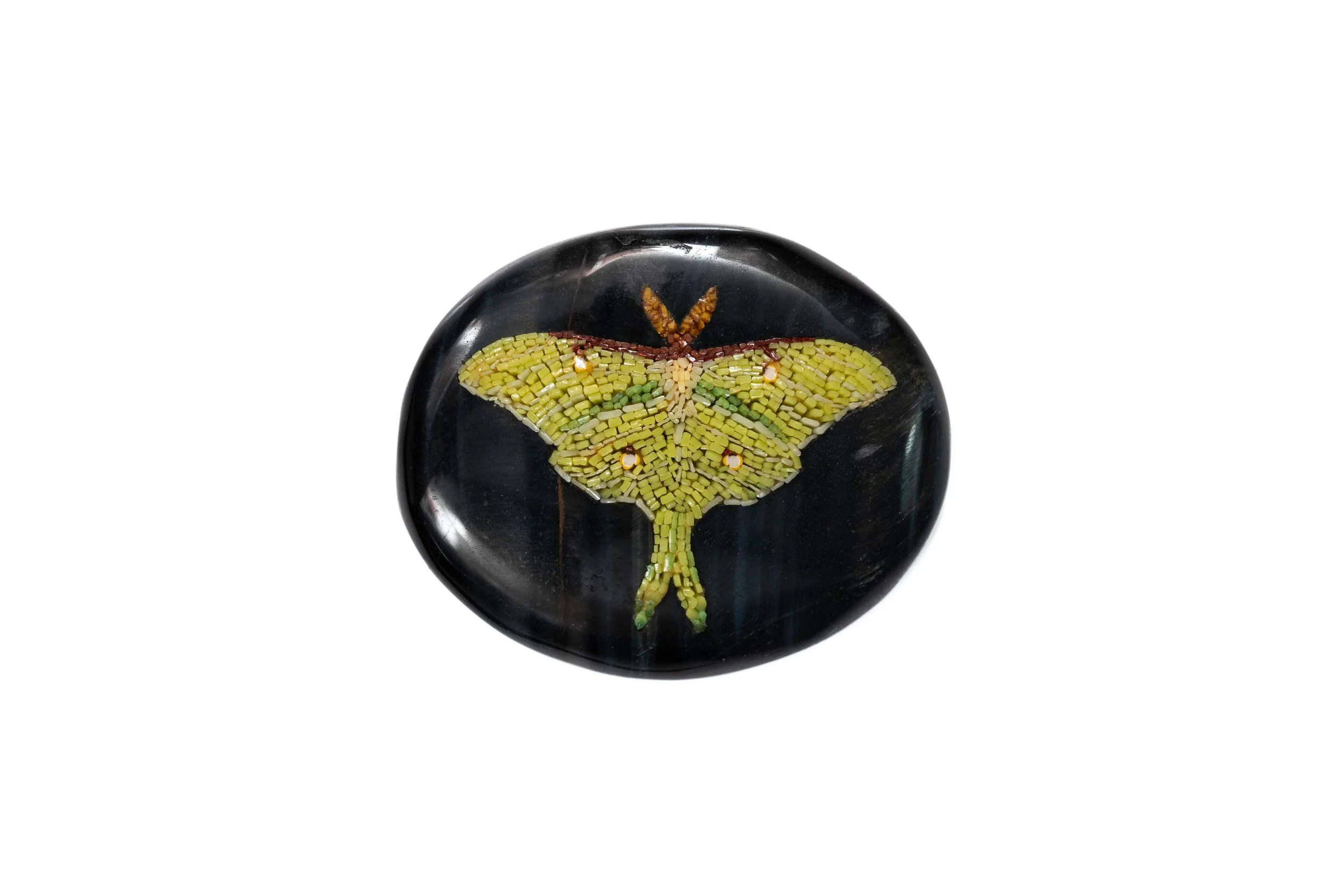 Pale green luna moth with long wing tails in micromosaic, set into a round black stone cabochon.