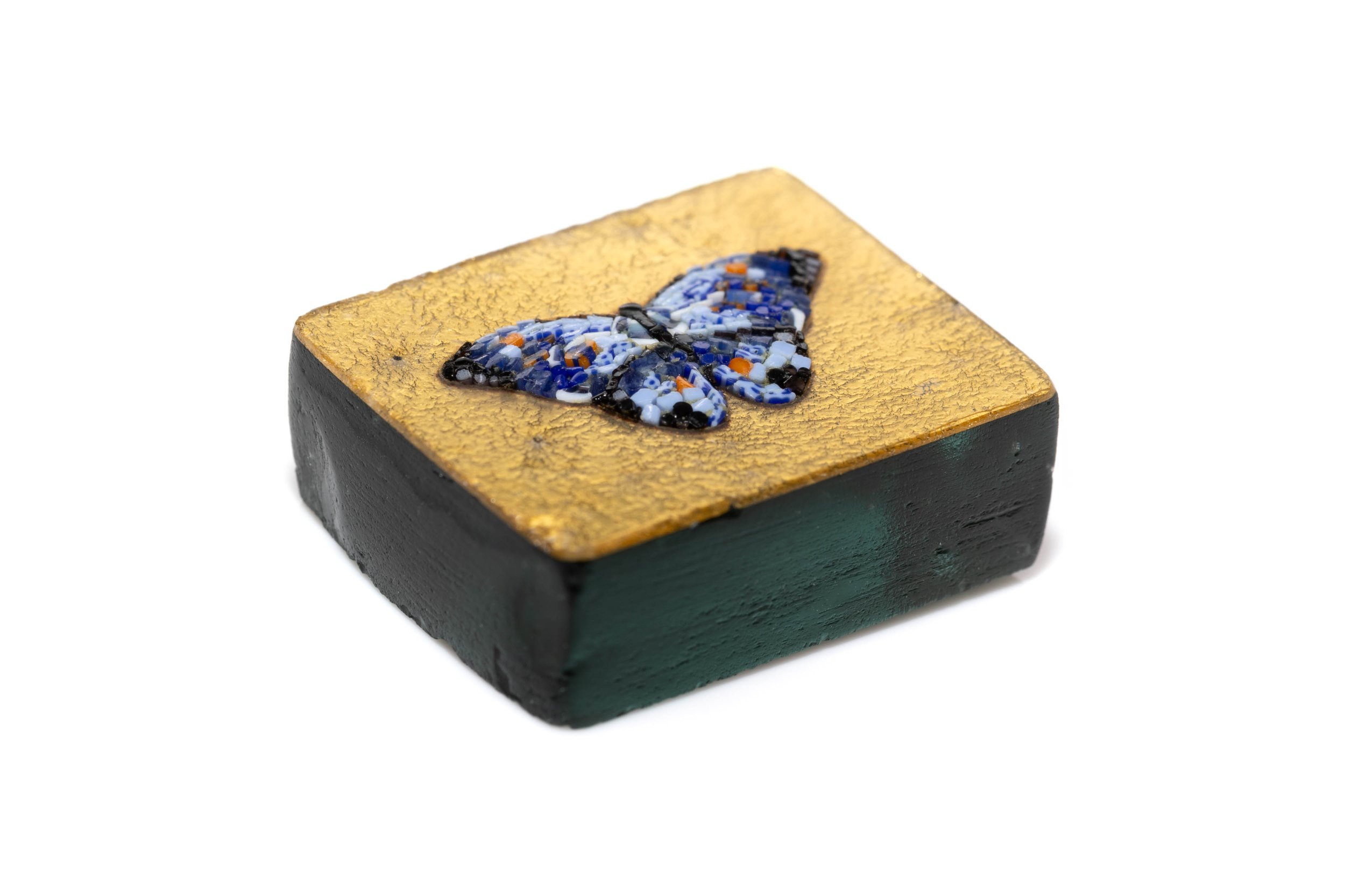 Close angled view of the blue butterfly micromosaic, showing the gold leaf surface and thick dark base.