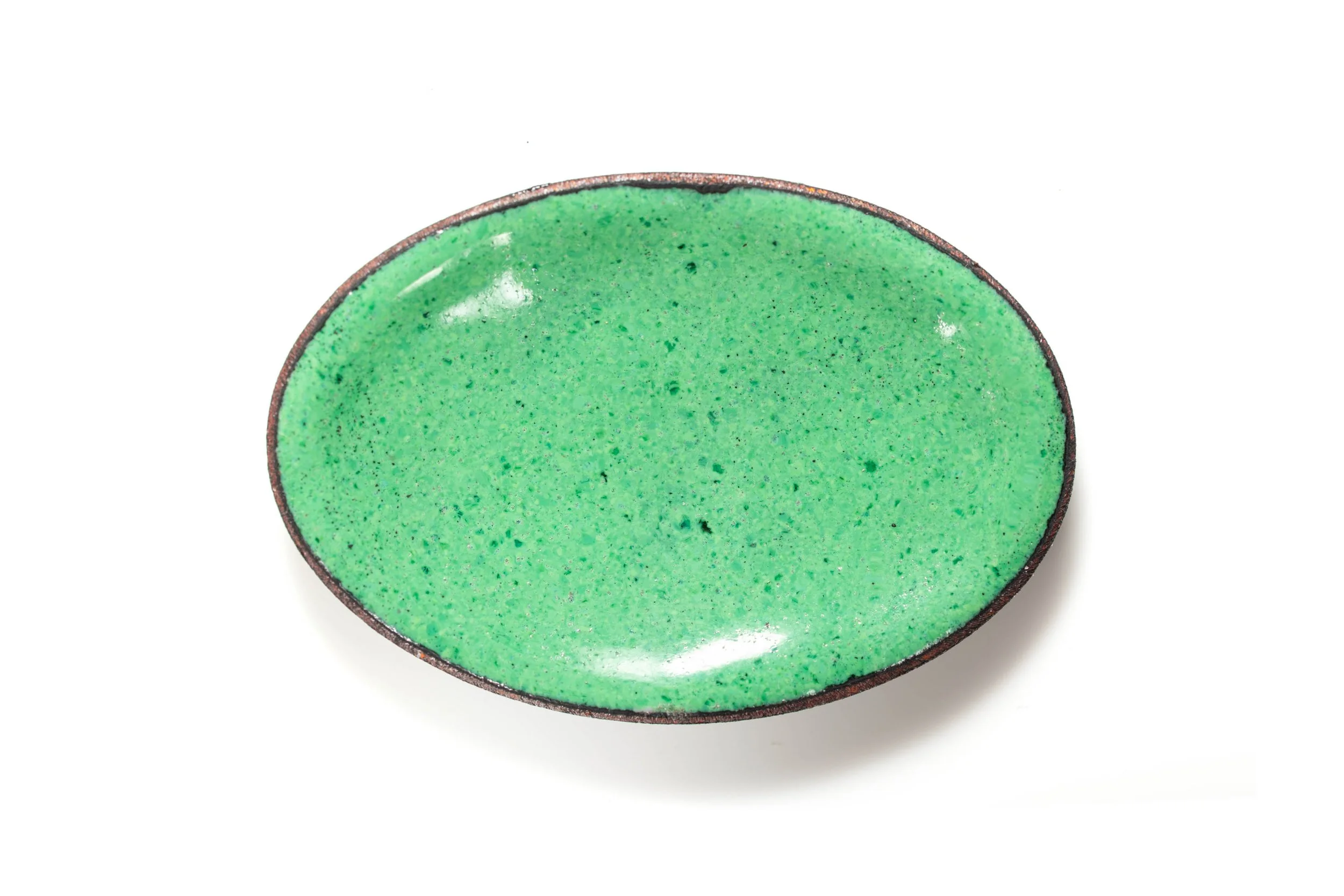 Rear view of the chameleon cabochon, showing its glossy pale green enamel back and oval metal edge.