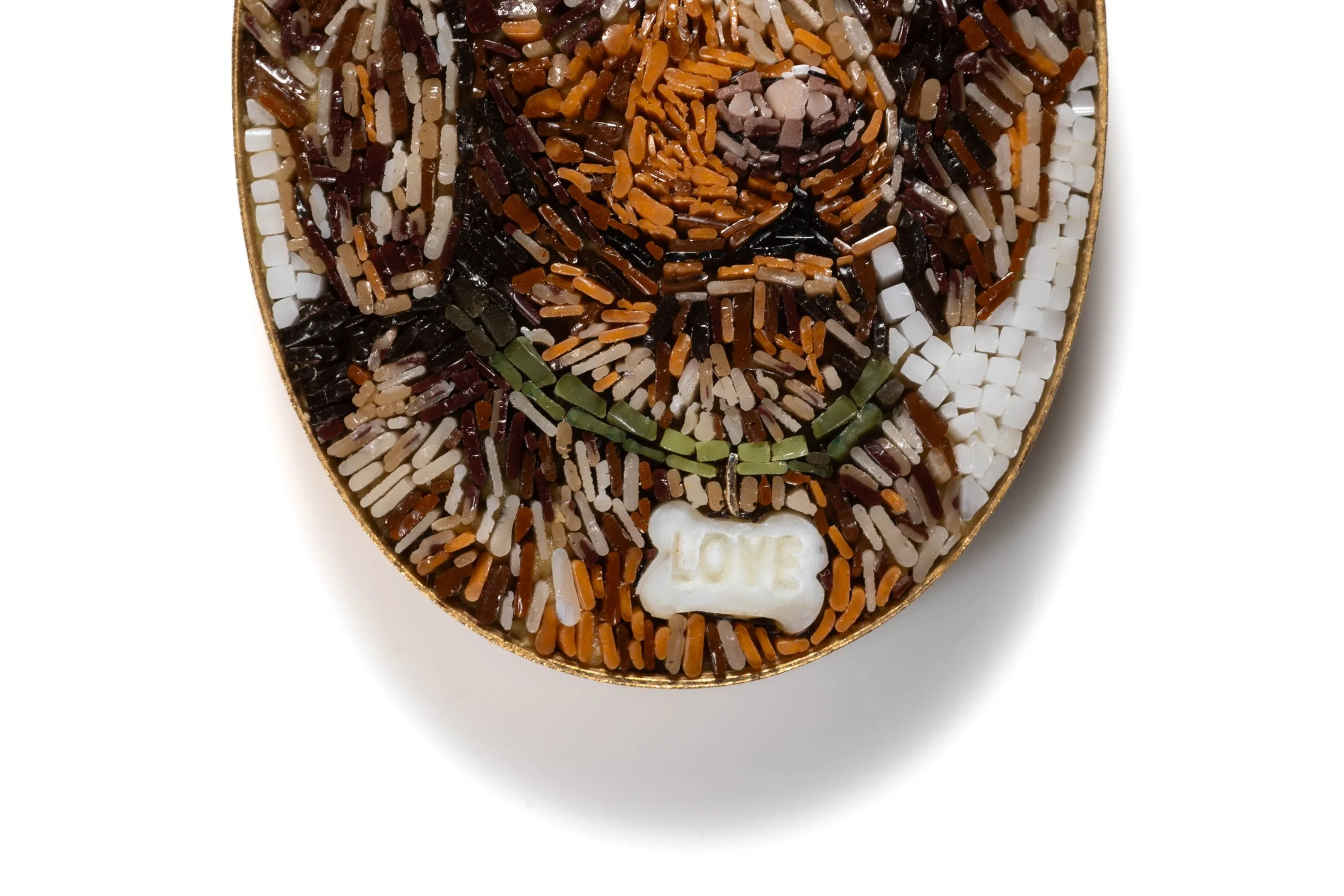 Close-up of the dog micromosaic, showing the muzzle, green collar and bone-shaped tag in tiny glass tesserae.
