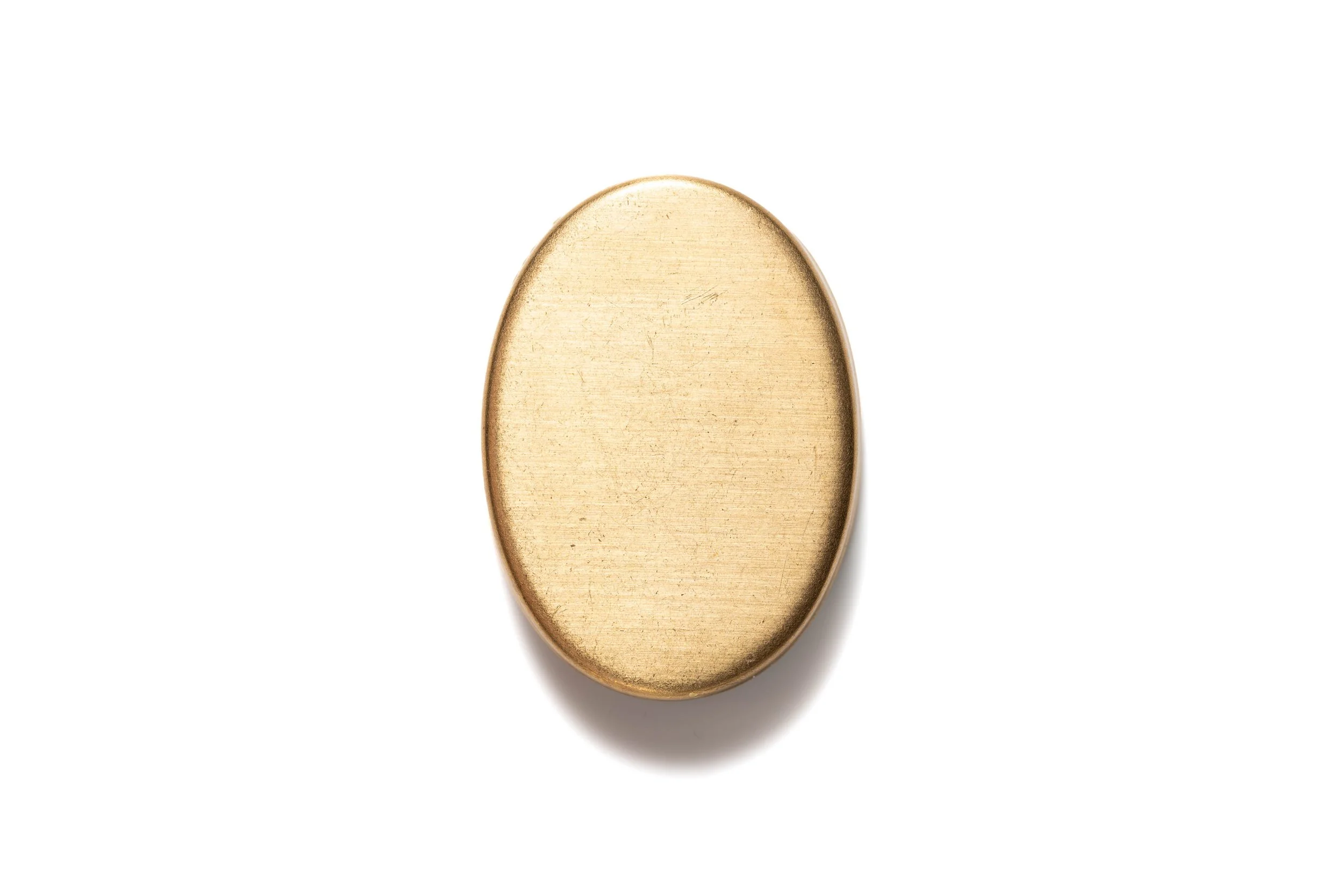 Rear view of the dog portrait cabochon, showing its plain gold-colored oval metal base.