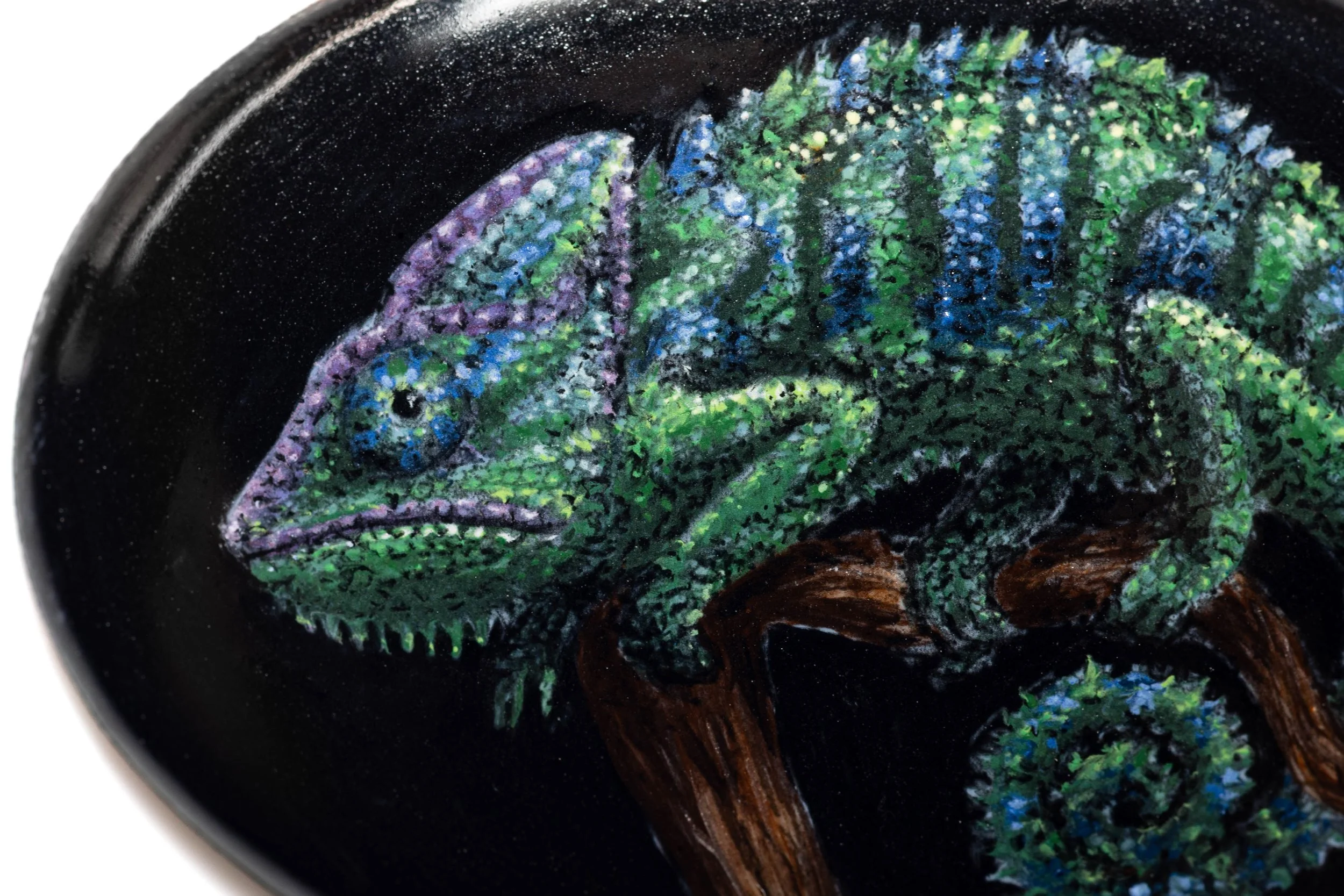 Close-up of the painted chameleon, showing the eye, textured skin and blue-green markings in vitreous enamel.