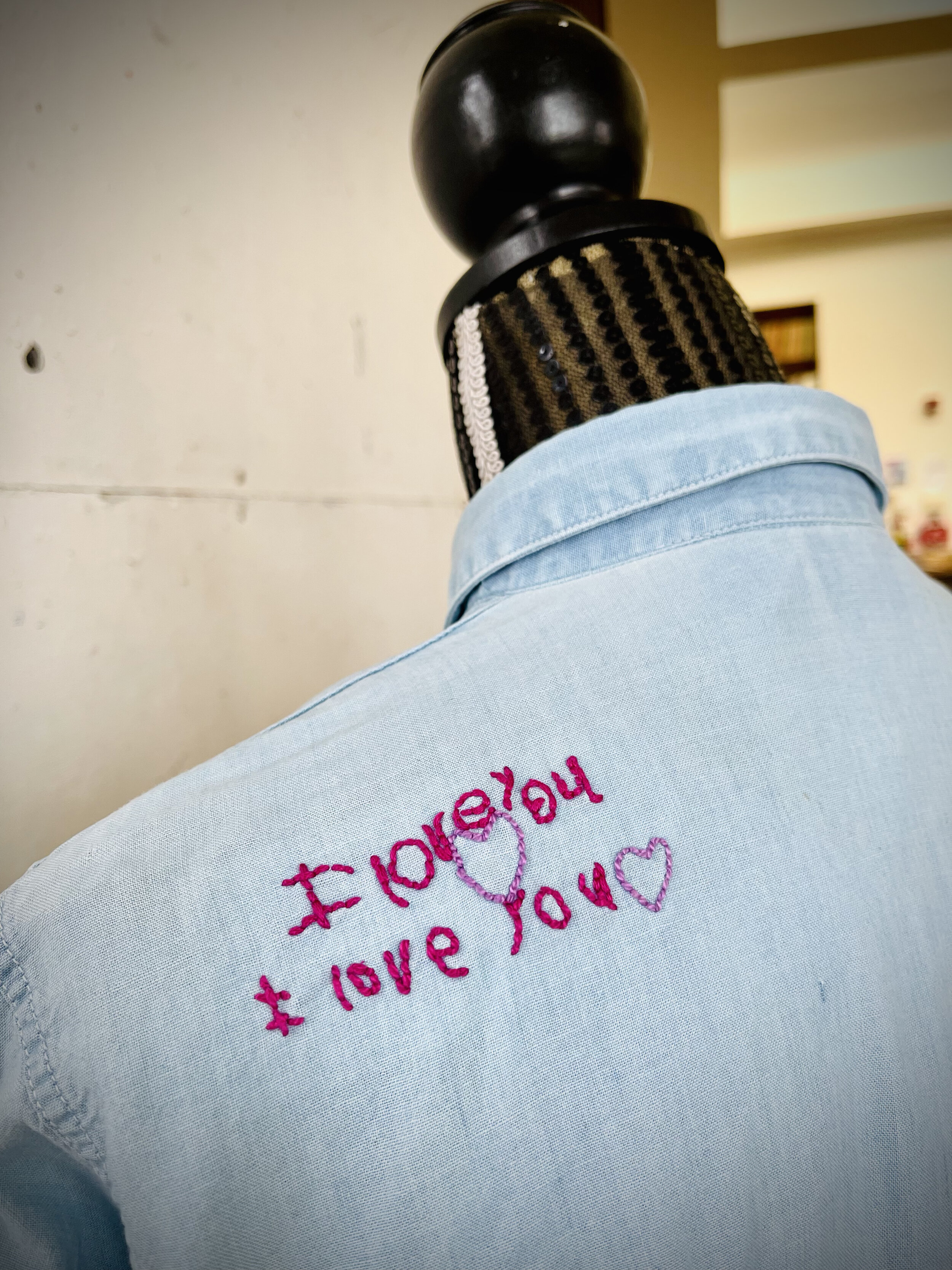 Children's drawings stitched onto a parent's shirt.
