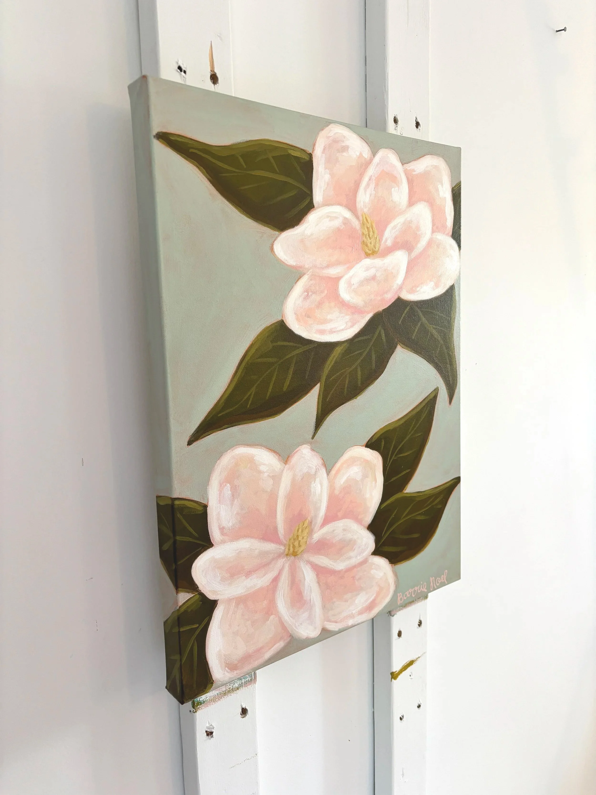 Original acrylic magnolia painting with pale pink blooms and soft green leaves on a light blue background.