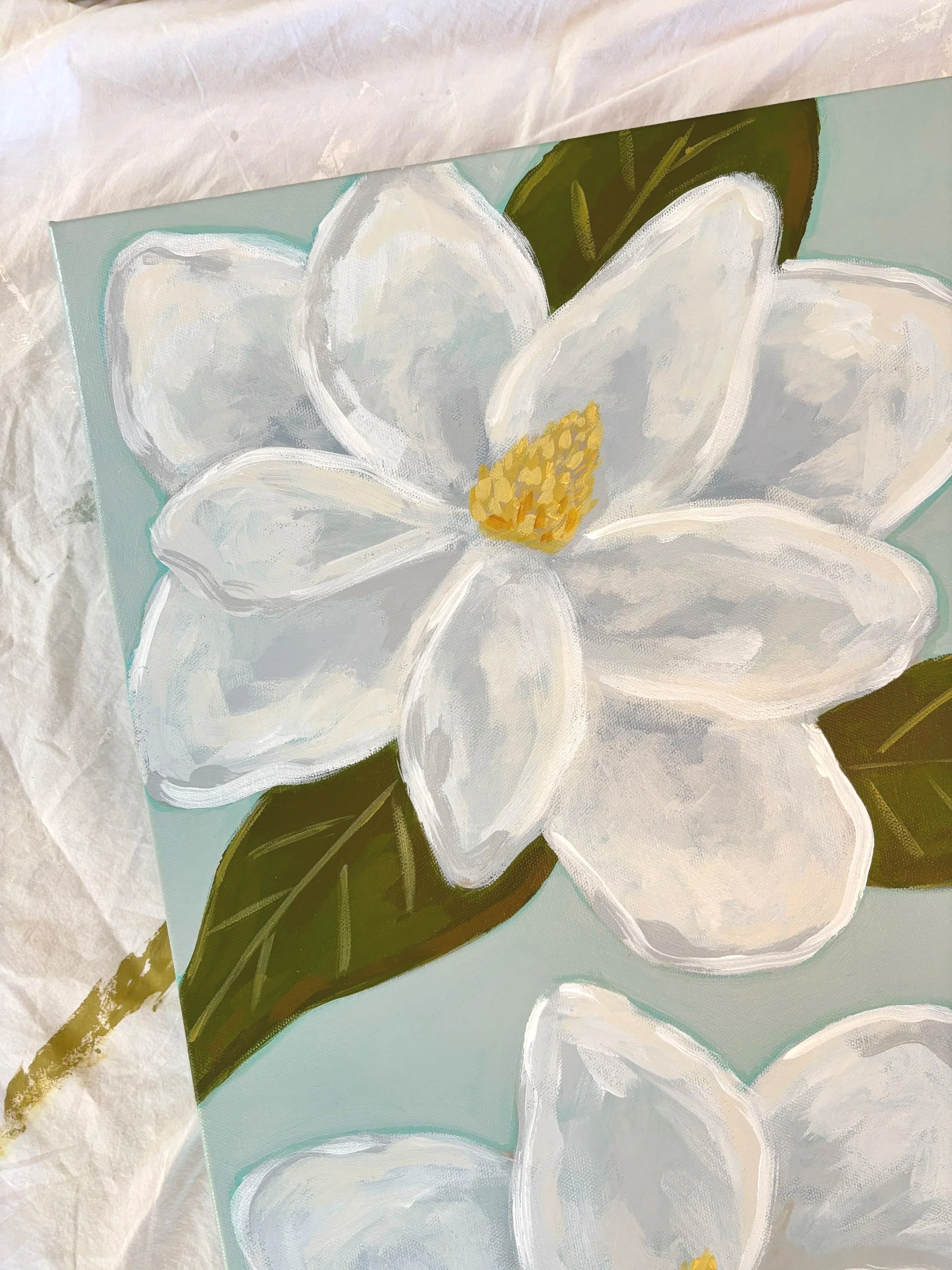 Original acrylic magnolia painting with creamy white blooms and soft green leaves on a light blue background.