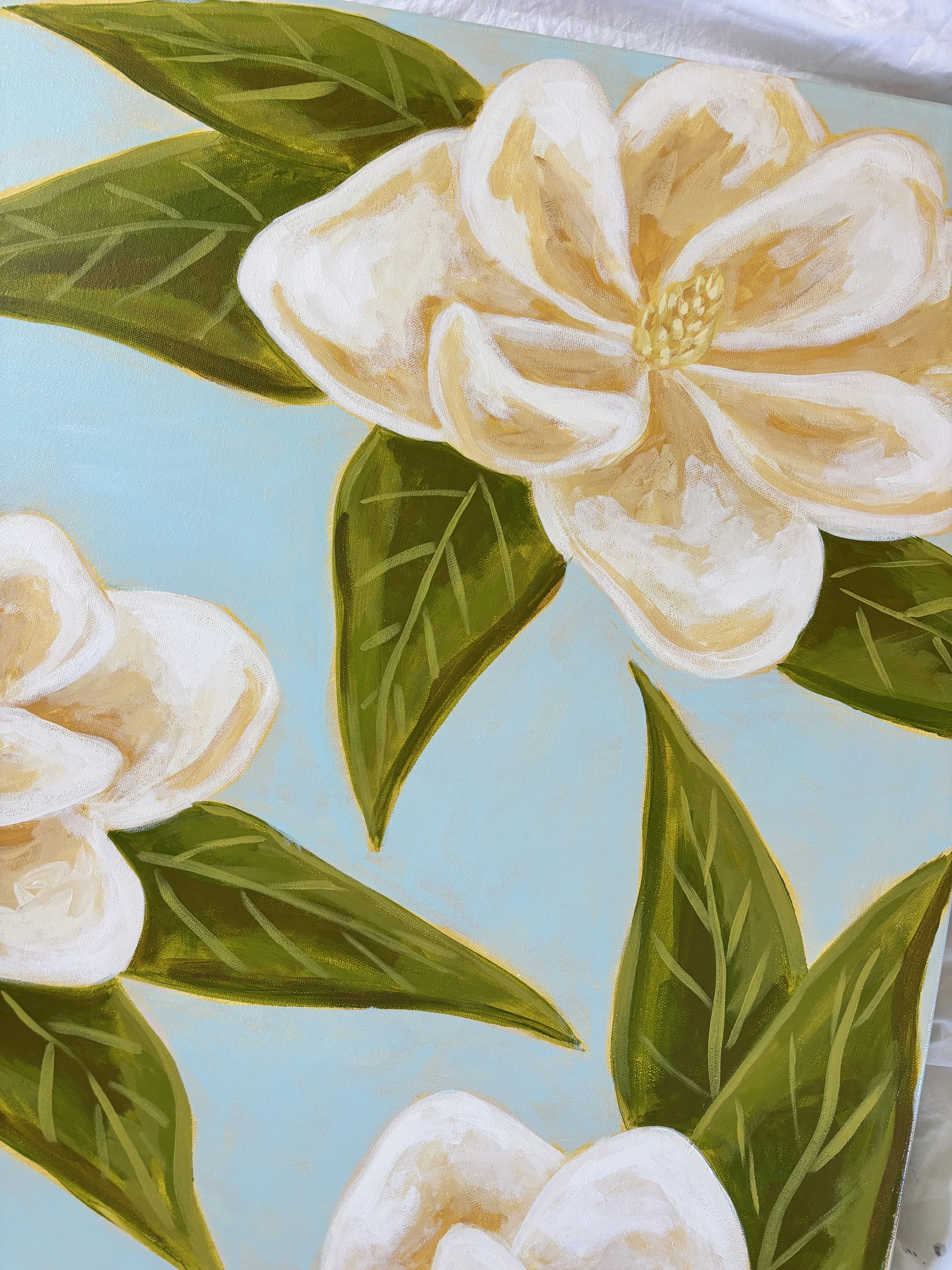 Original acrylic magnolia painting with cream blooms and soft green leaves on a light blue background.