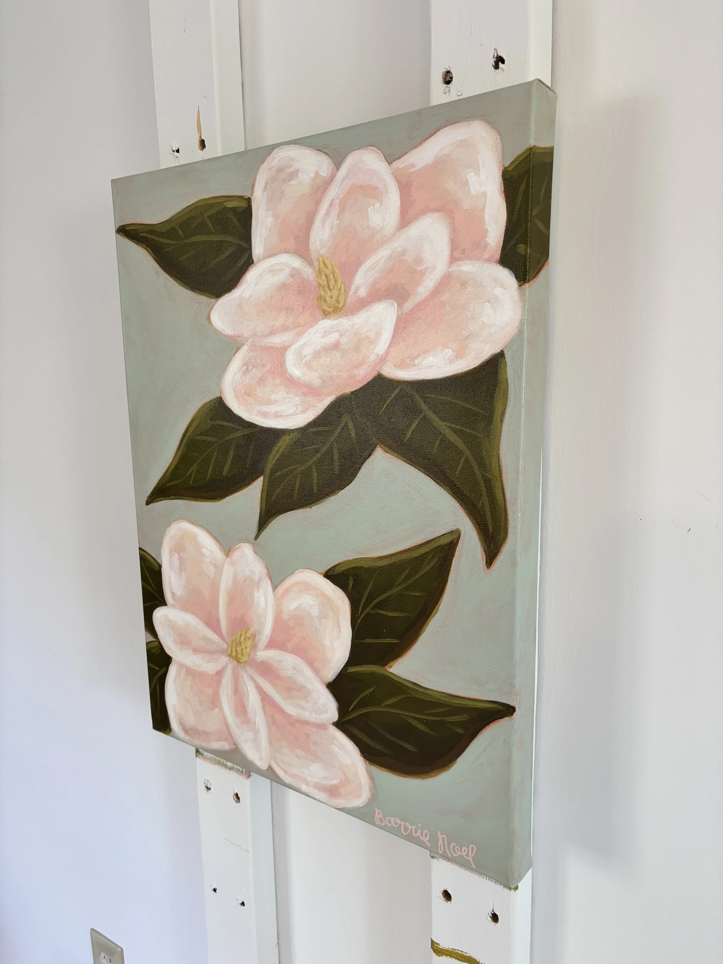 Original acrylic magnolia painting with pale pink blooms and soft green leaves on a light blue background.