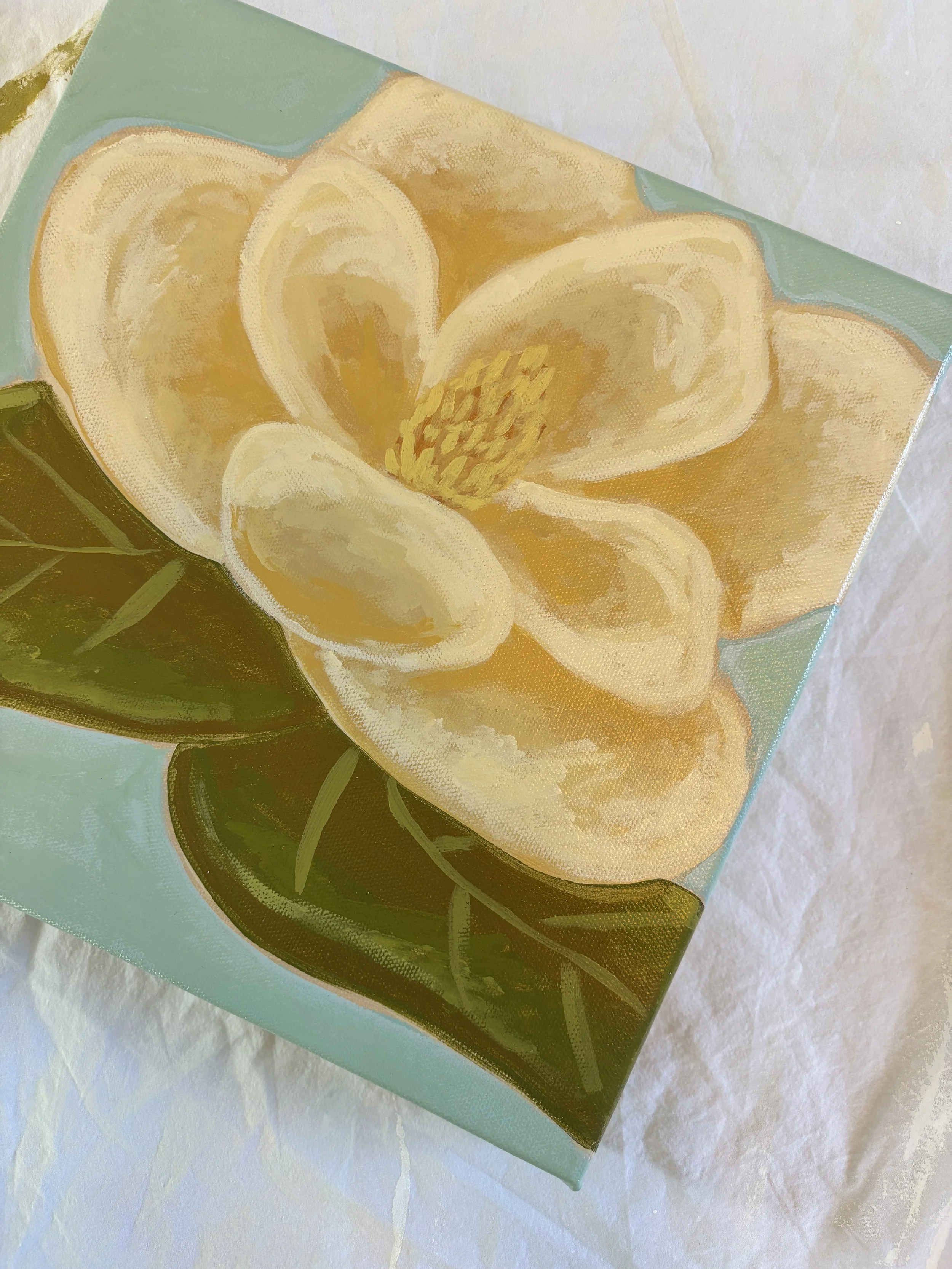 Original acrylic magnolia painting with cream blooms and soft green leaves on a light blue background.