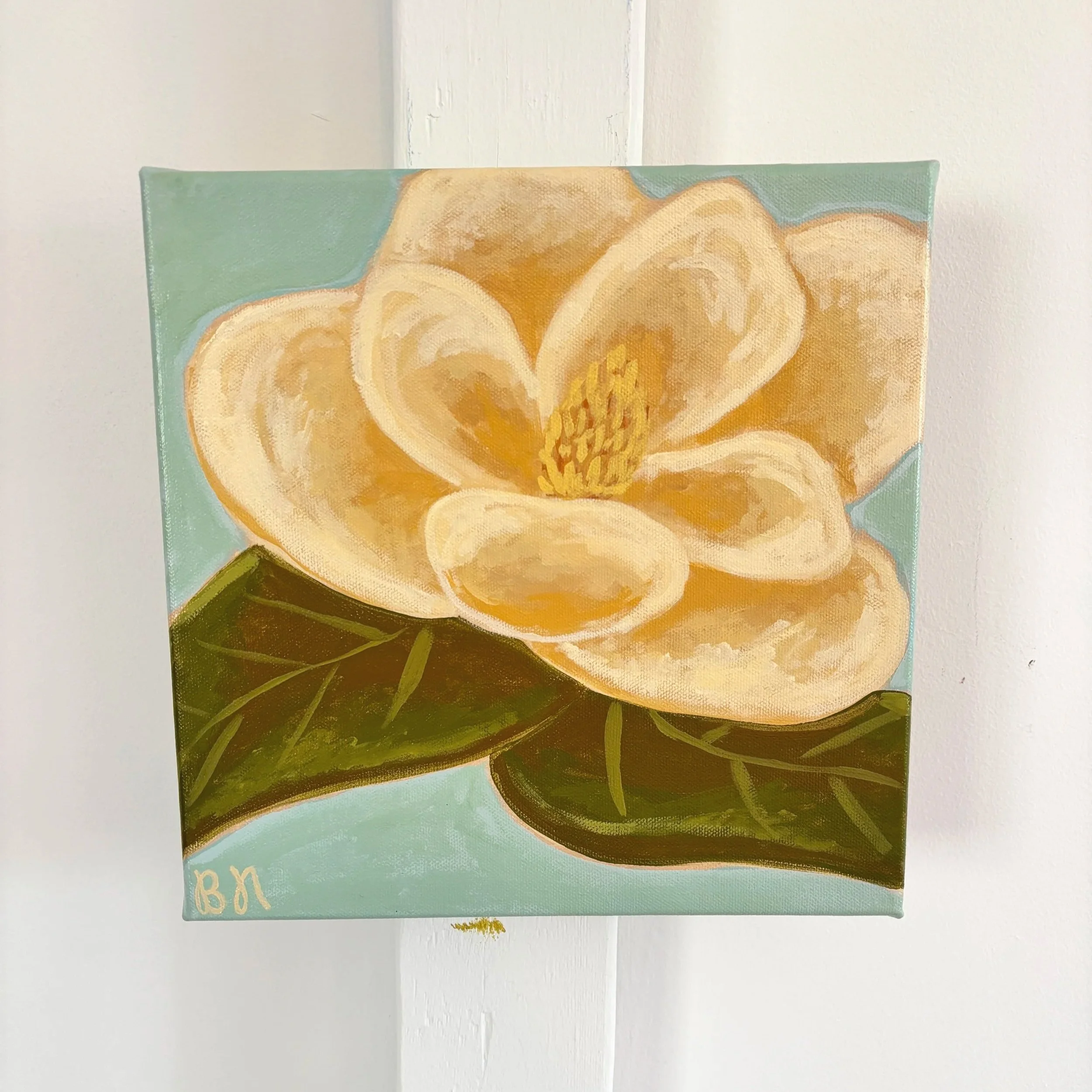 Original acrylic magnolia painting with cream blooms and soft green leaves on a light blue background.