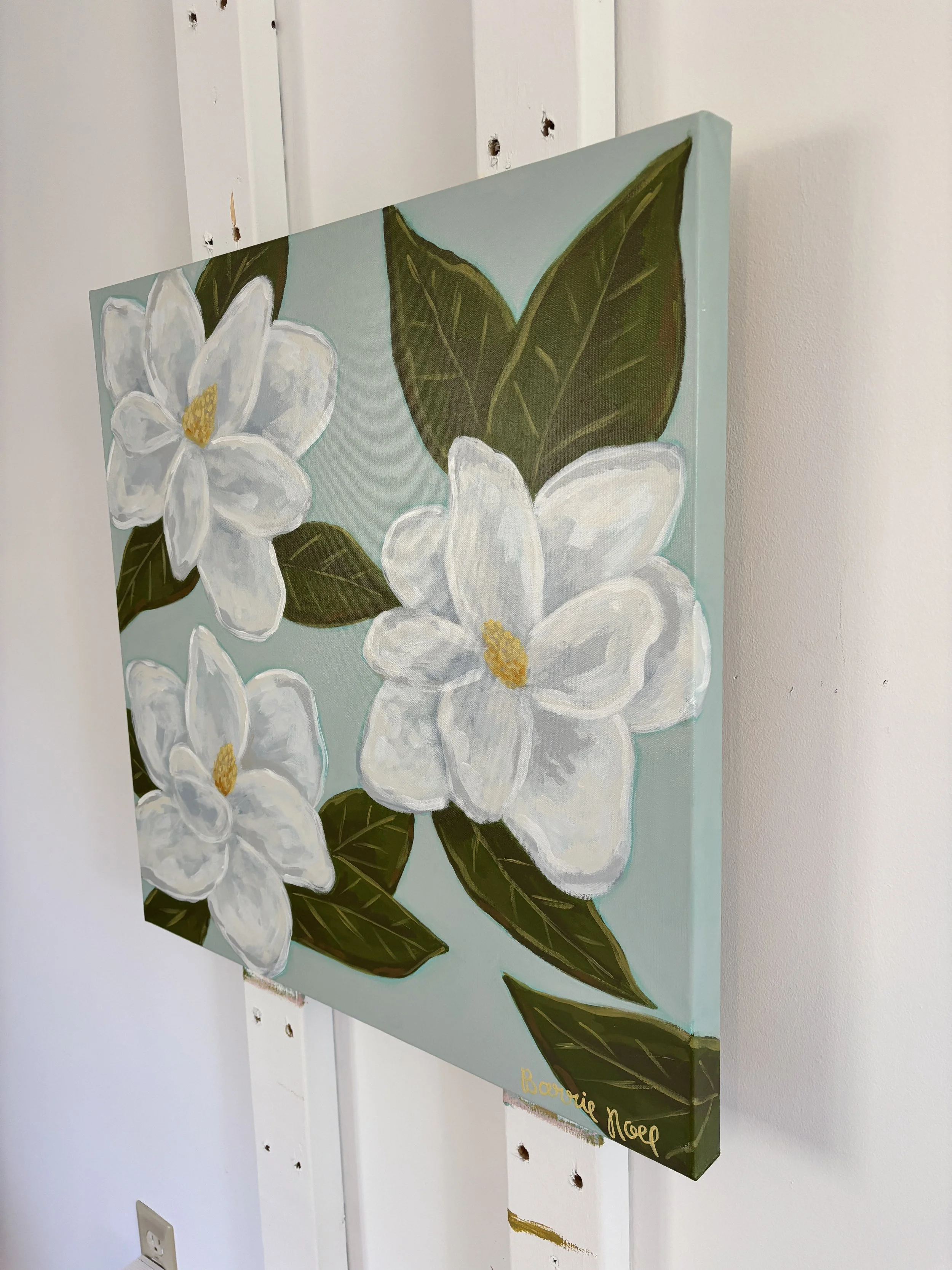Original acrylic magnolia painting with creamy white blooms and soft green leaves on a light blue background.