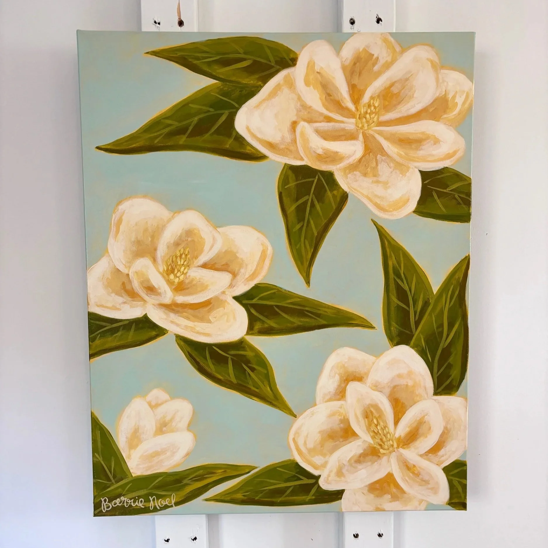 Original acrylic magnolia painting with cream blooms and soft green leaves on a light blue background.