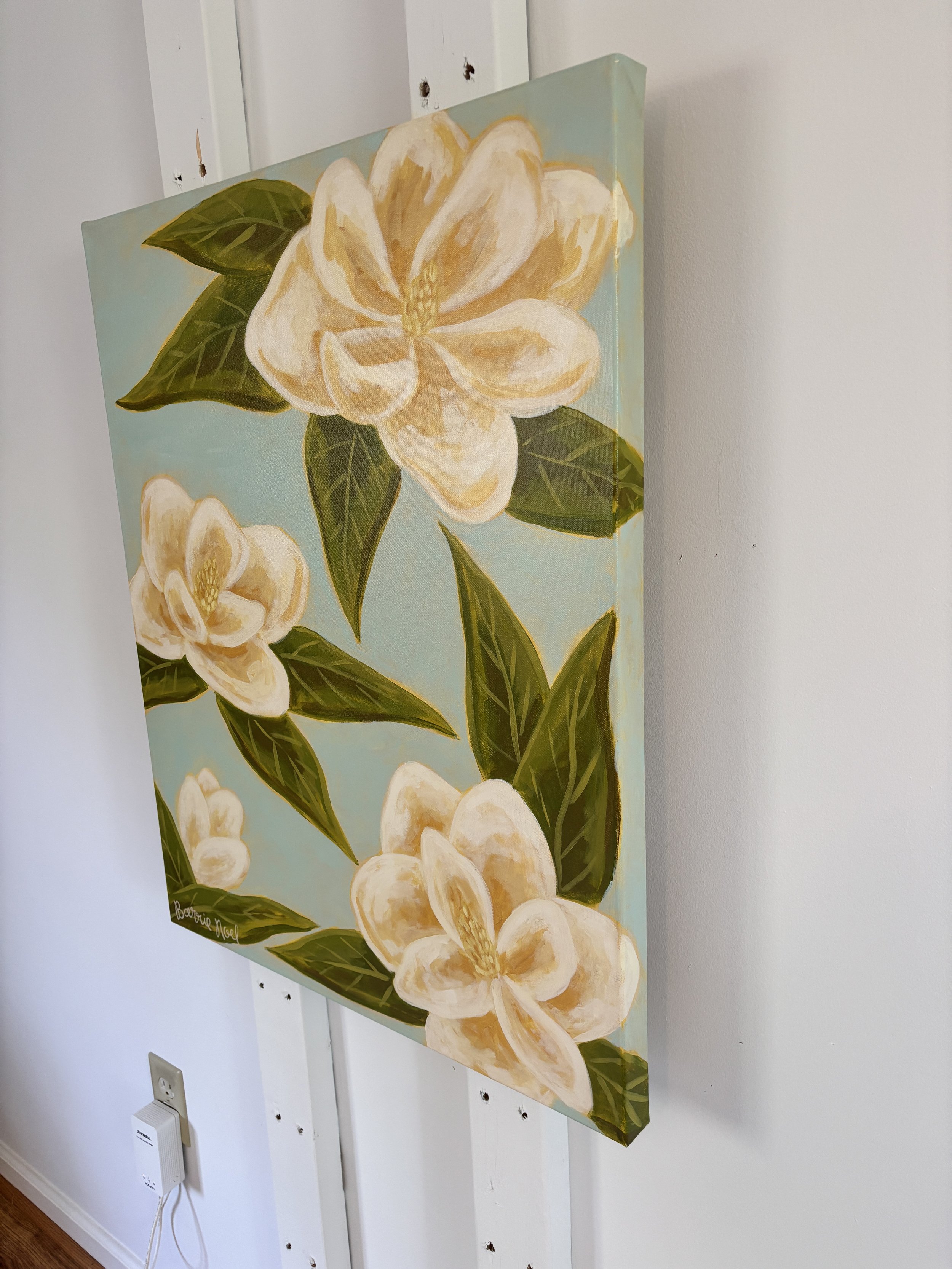 Original acrylic magnolia painting with cream blooms and soft green leaves on a light blue background.