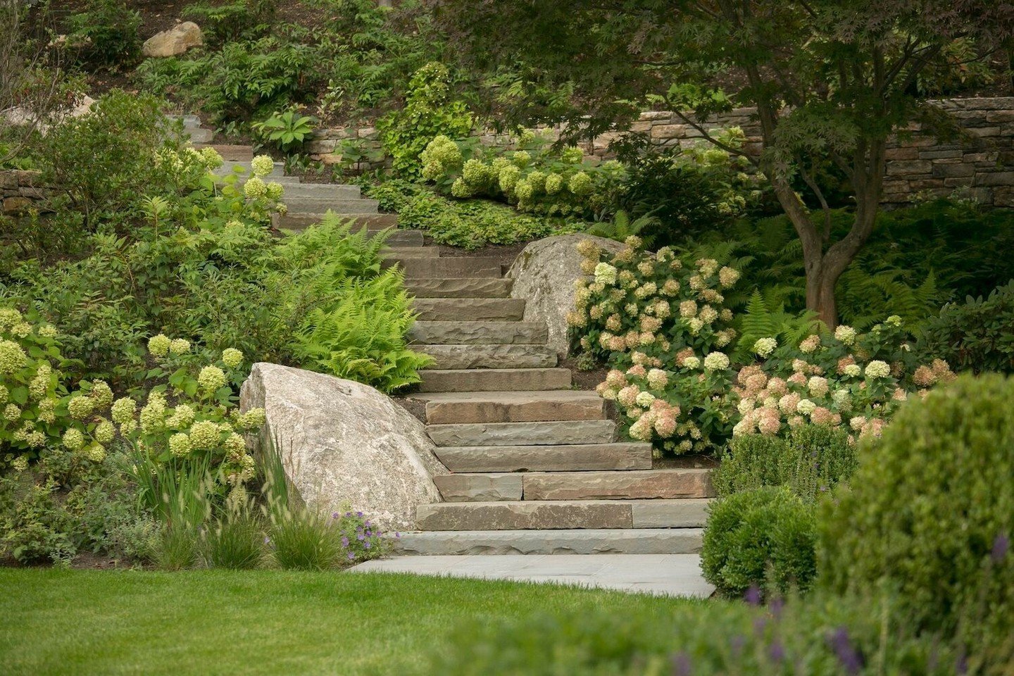 From these stone steps to the view from where they're laid (swipe to see), this Greater Boston backyard offers everything for outdoor living this season. ⁠
⁠
Visit the link in our bio for every detail of this space, ready for all kinds of gathering a
