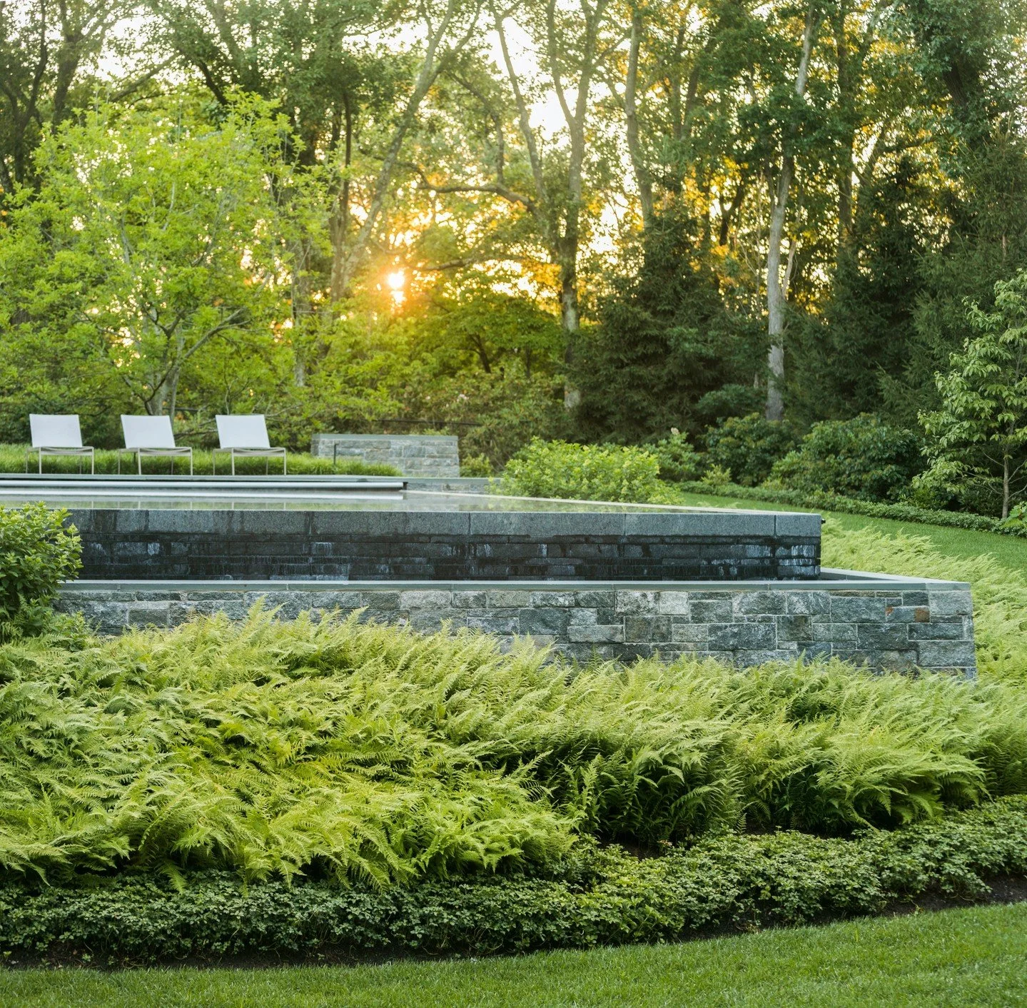 This poolside landscape in Greater Boston is all about contrast. Crisp stone detailing set against sweeping drifts of plantings result in an outdoor space that feels both refined and seamlessly connected to the surrounding woodland.⁠
⁠
Photography: @