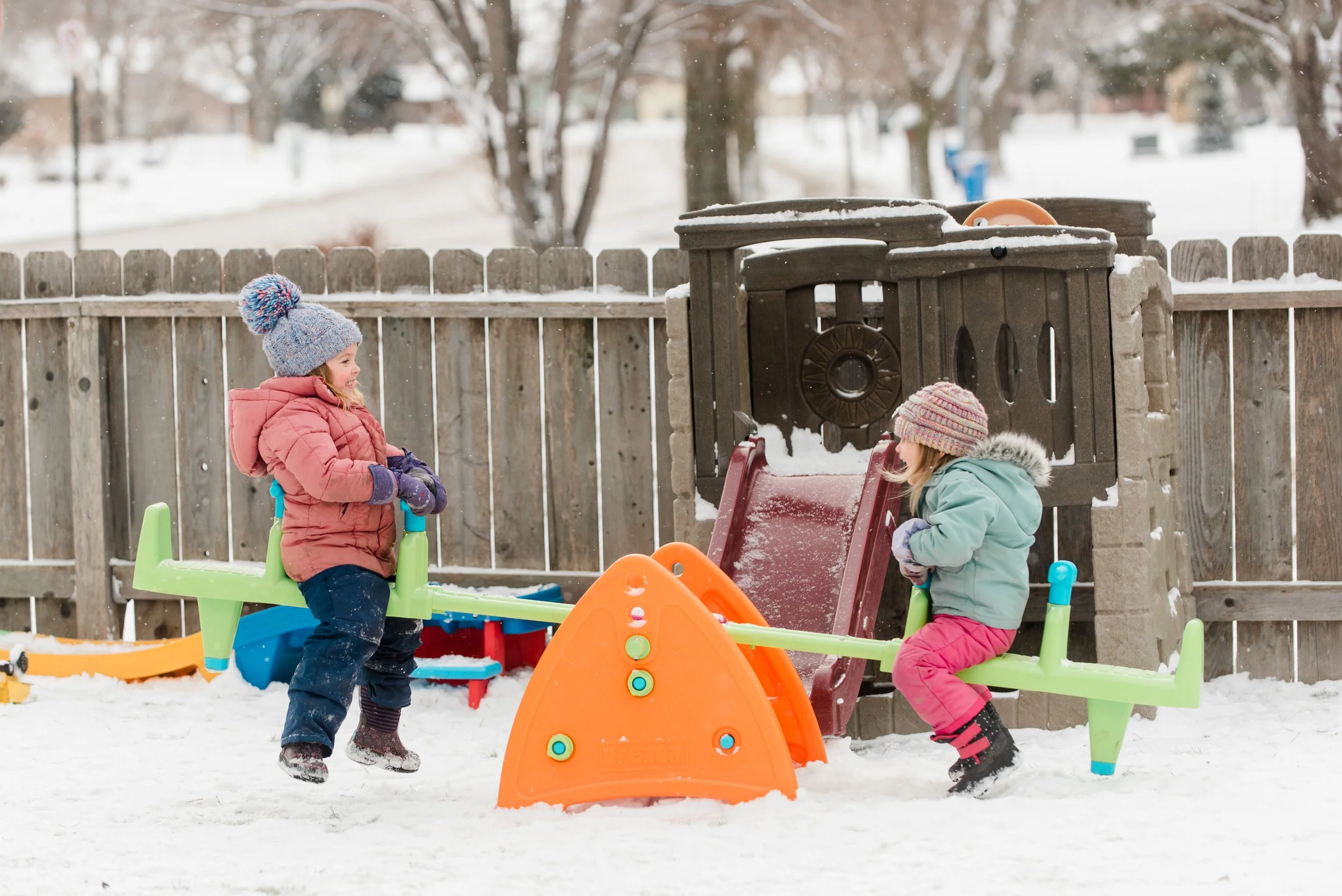 Two girls in snow gear on a seasaw