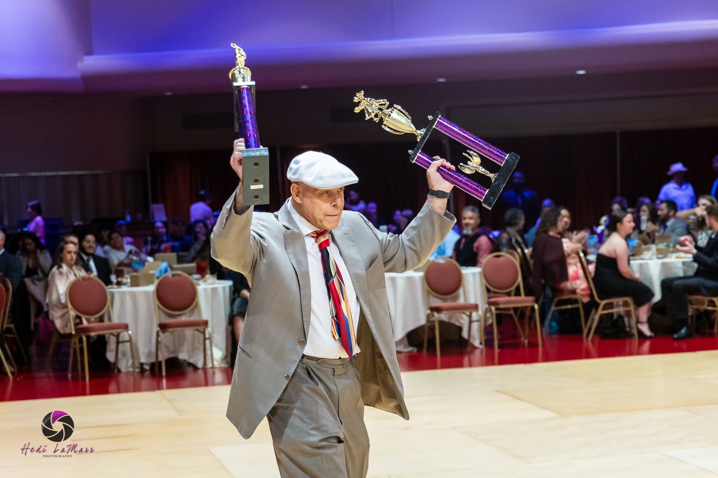Fred Marshall, volunteer coordinator, presenting trophies at the 2026 Celebrity Dance Competition Event at 22nd Annual Rhumba 4 Rainbow Gala