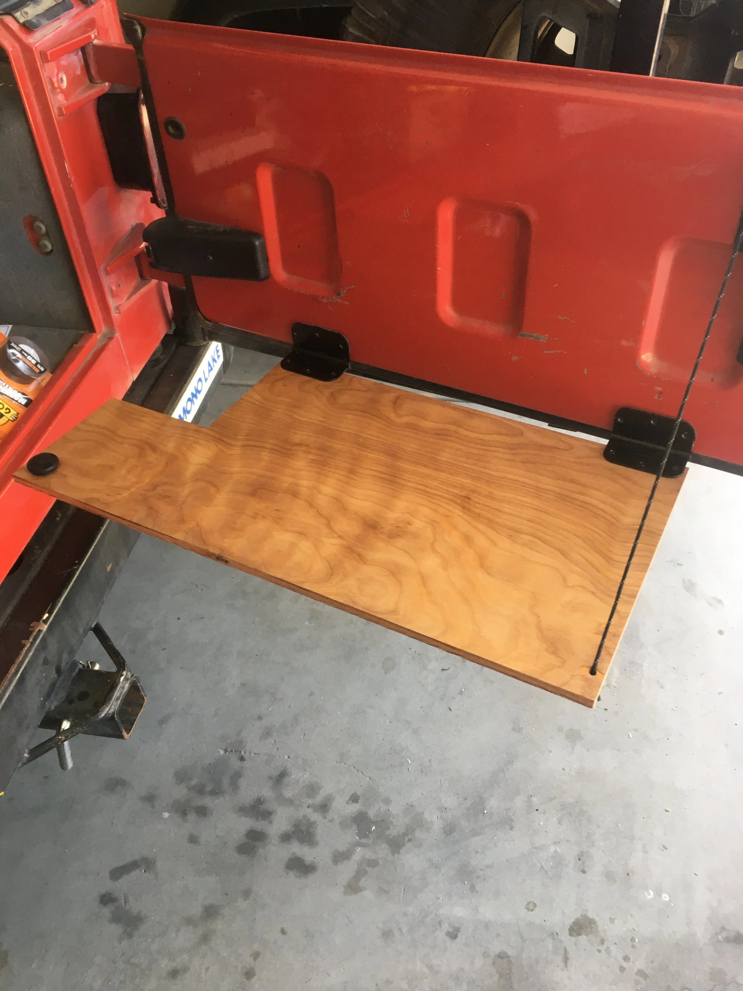 Tailgate Table in open position. Mounted via adhesive and paracord; Rated loads at 50lbs and 100lbs, respectively. Weight tested with incrementing dumbbells confirm 50lbs without extreme deformation.    