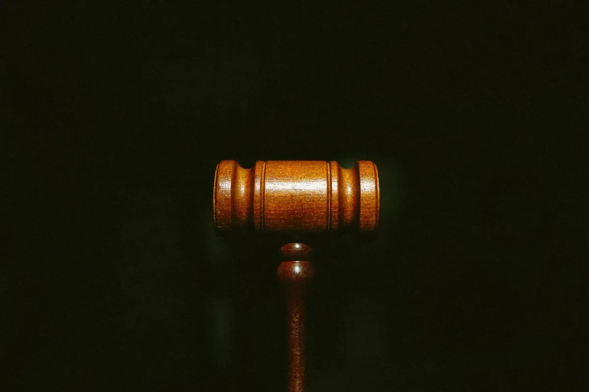 Wooden gavel on a dark background, symbolizing law or justice.
