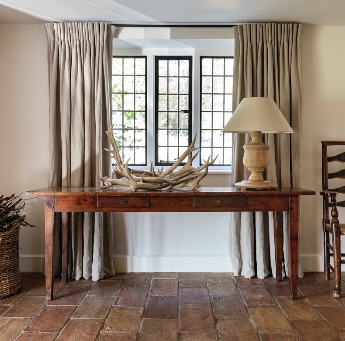 A classic country welcome 🤎

In this entrance hall from our Wiltshire project, reclaimed terracotta tiles give a warm and relaxed finish whilst also being hard wearing. Neutral heavy weight linen curtains add further texture, and the antique furnitu