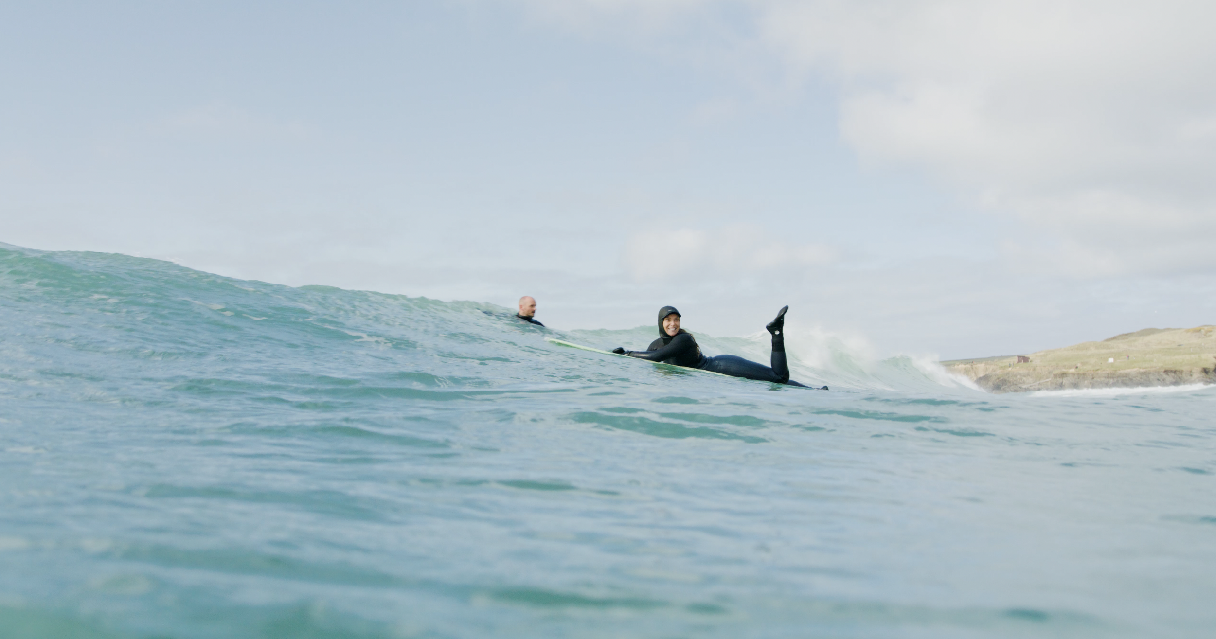 A surfer paddles outs in protest