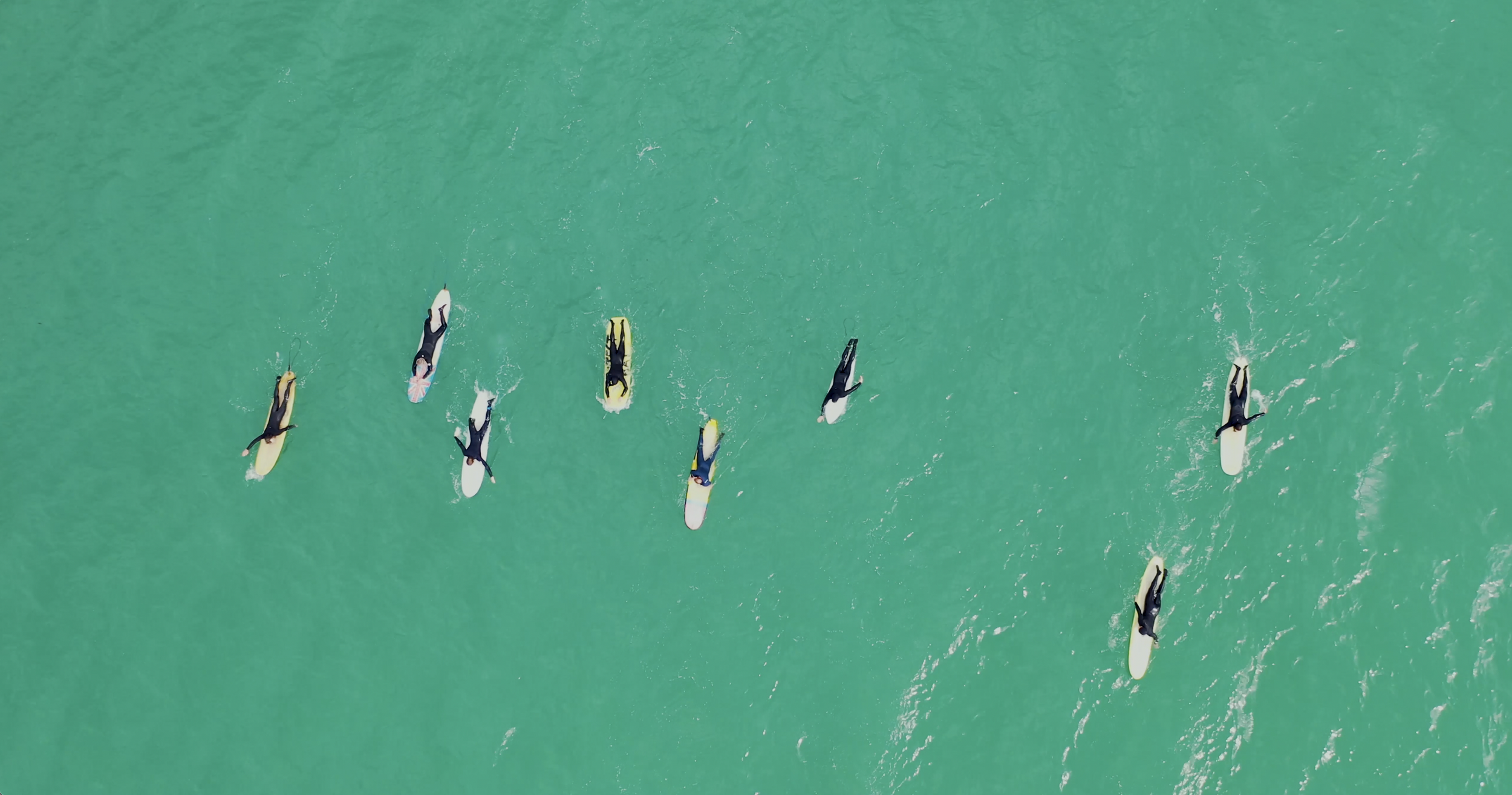 Surfers paddling out for the circle