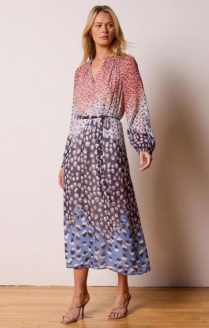 A model wearing a lovely printed pink, white and blue abstract dot dress from Nic and Zoe with a belted waist.